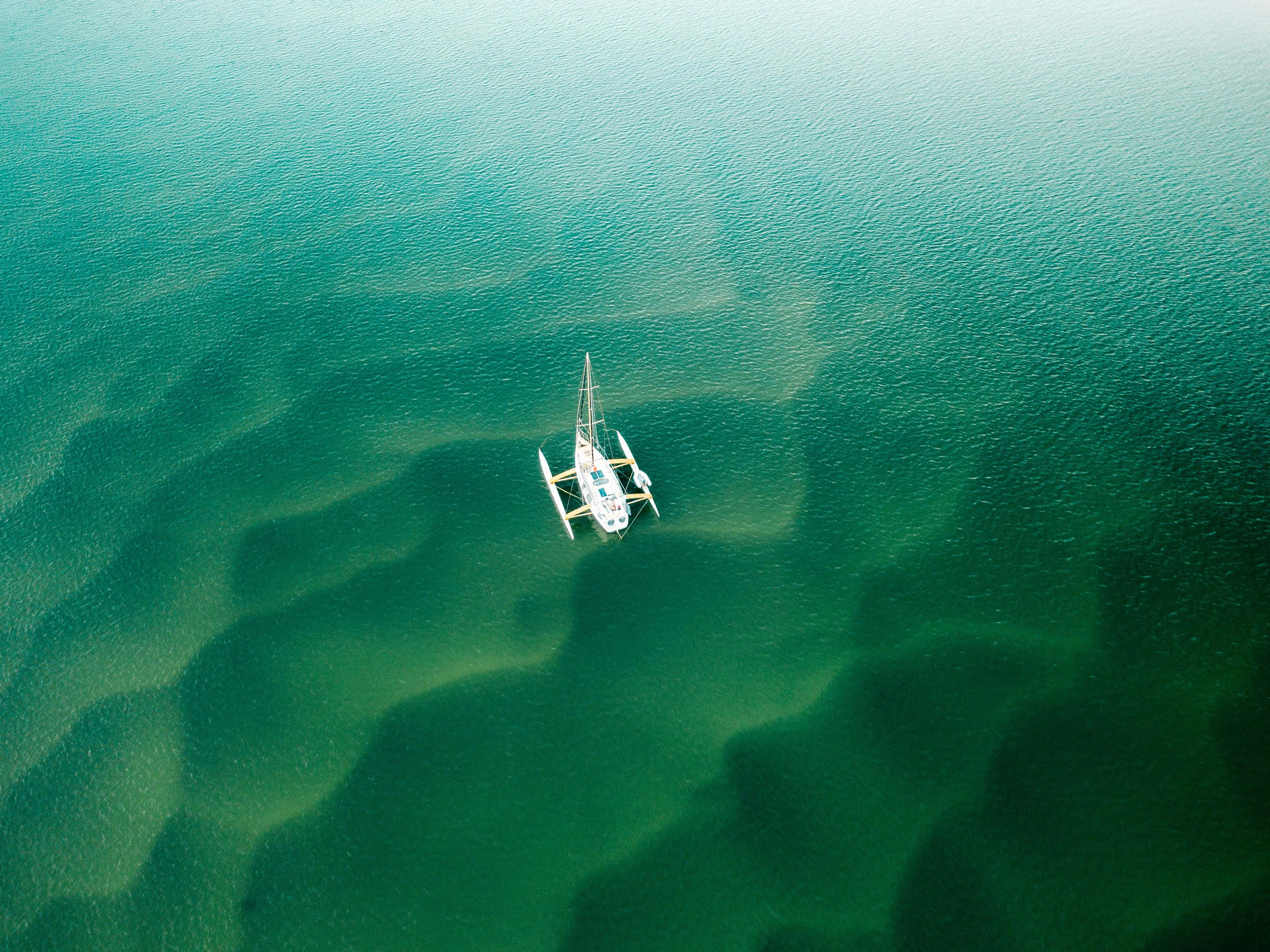 Emerald Waters Solitary Sailboat, white catamaran, turquoise water, 2K Desktop Wallpaper