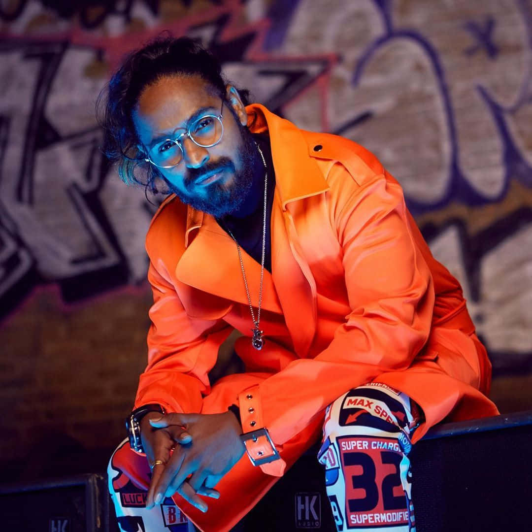 Emiway Bantai, orange jacket, graffiti-covered wall, SD Desktop Wallpaper