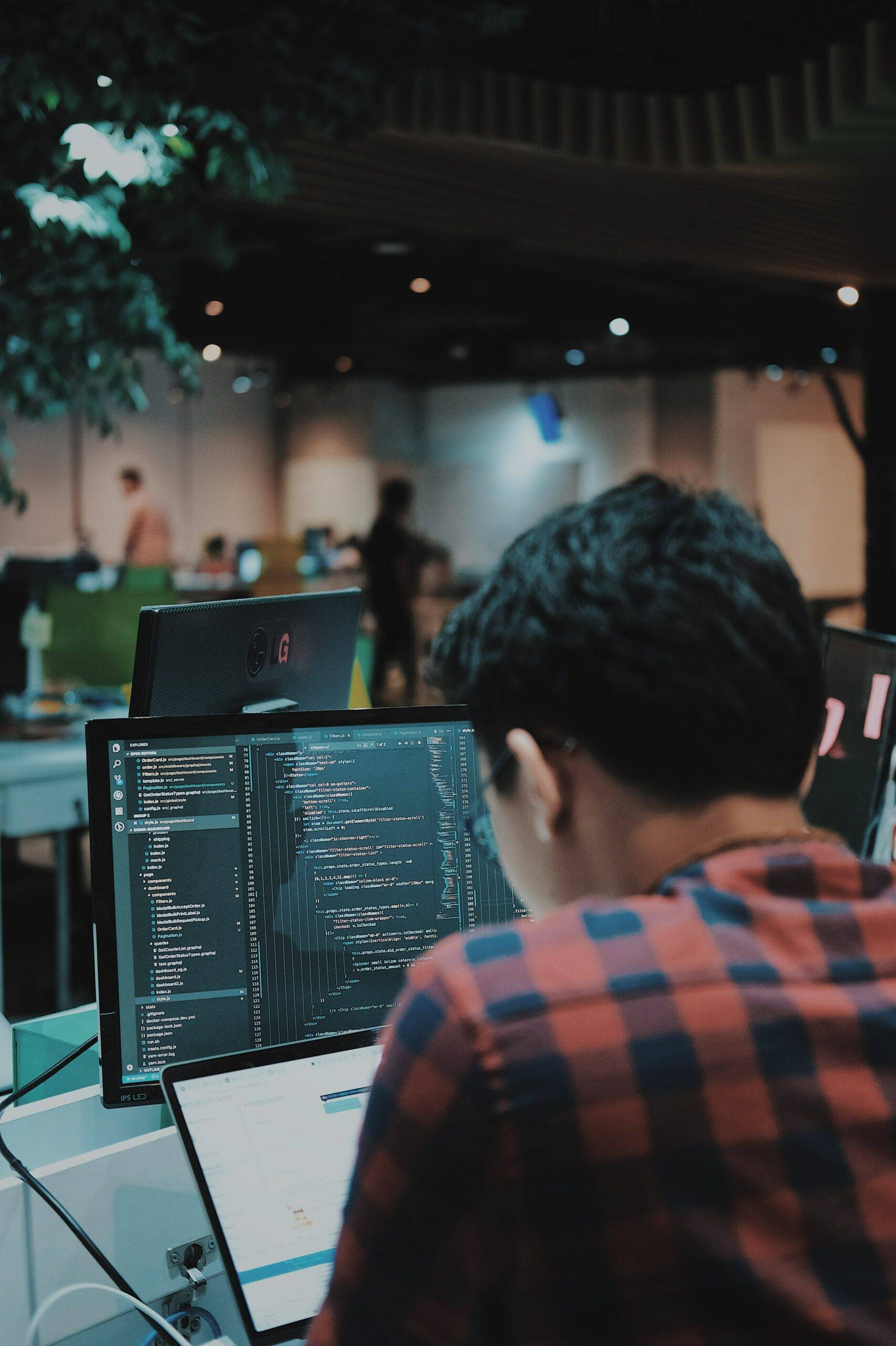 plaid shirt, multiple monitors, dimly lit modern office space, 2K Phone Wallpaper
