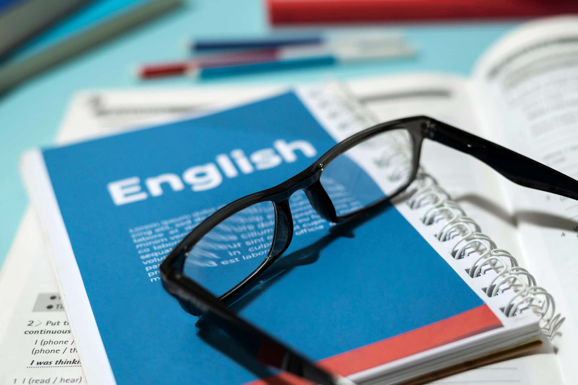 English textbook, black-framed glasses, light blue desk, Full HD Desktop Wallpaper