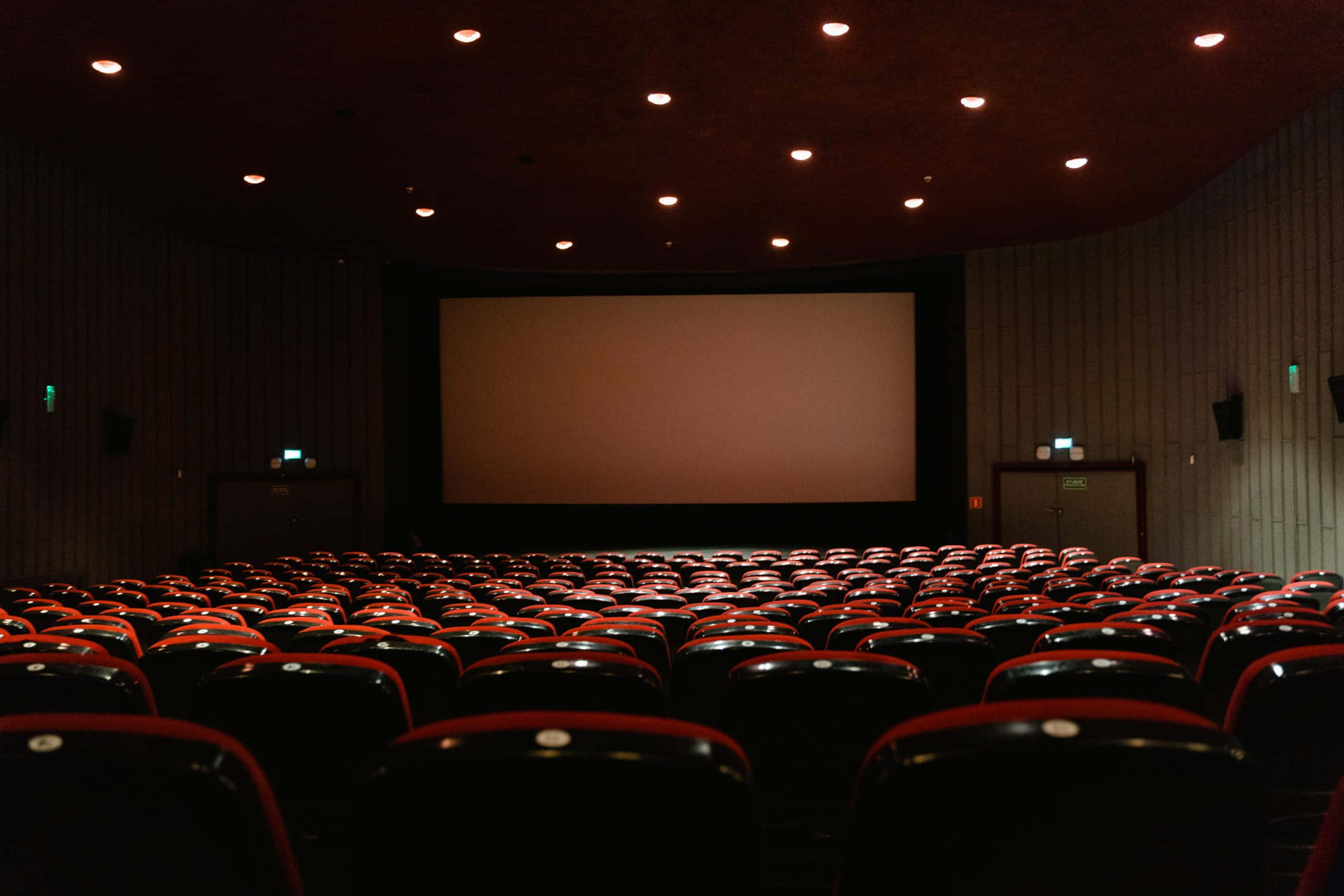 red cinema seats, blank screen, dim ceiling lights, 2K Desktop Wallpaper