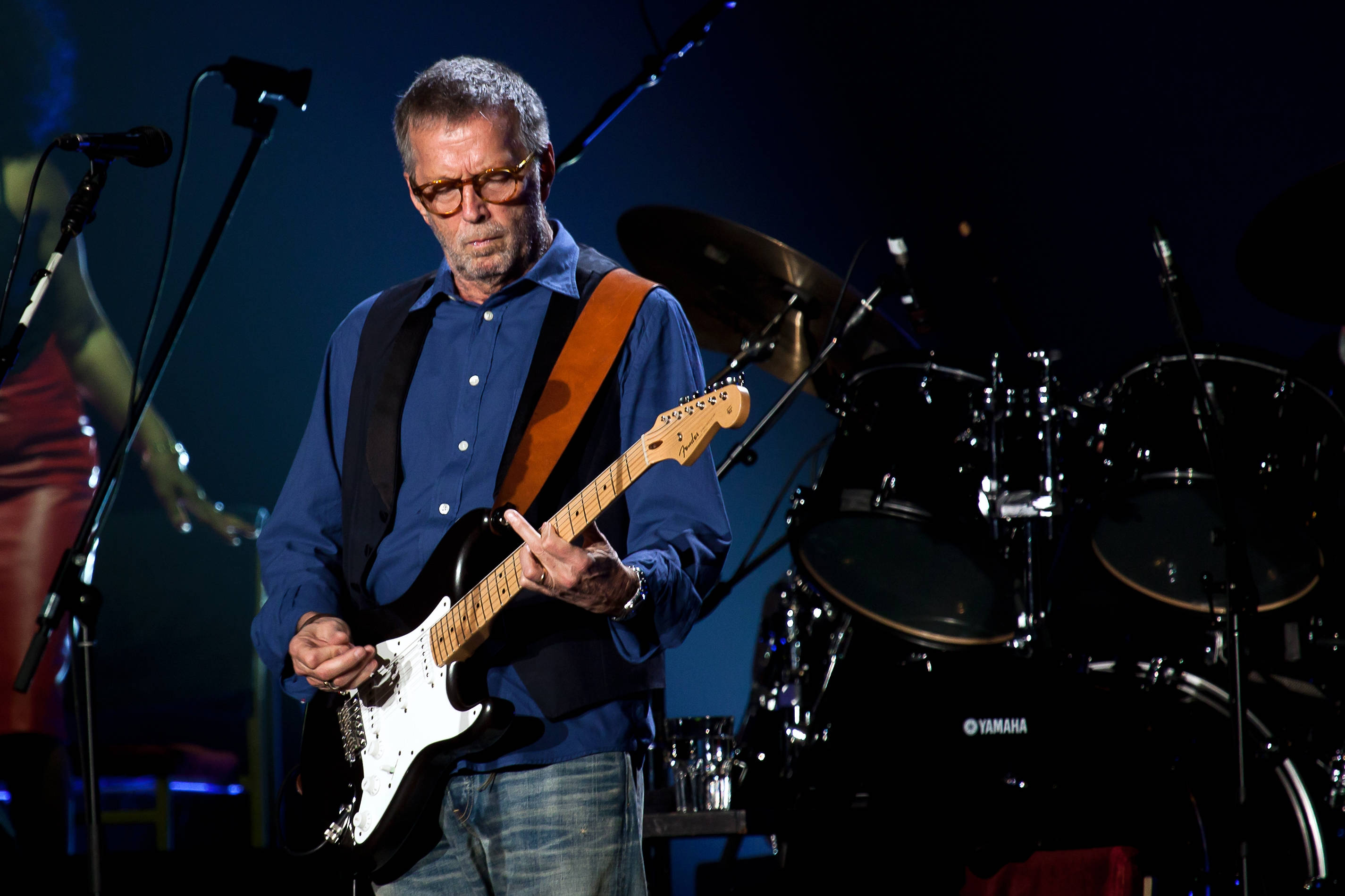 Eric Clapton, black electric guitar, dimly lit stage, 2K Desktop Wallpaper