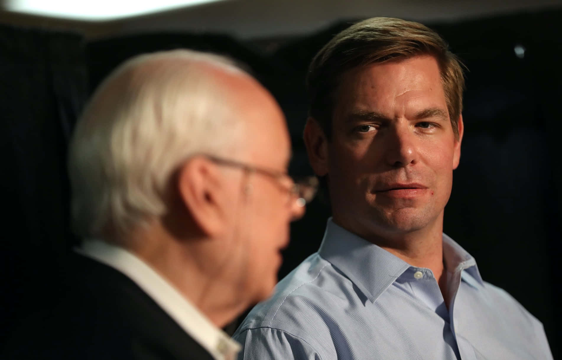 Eric Swalwell, formal attire, dimly lit room, HD Desktop Wallpaper