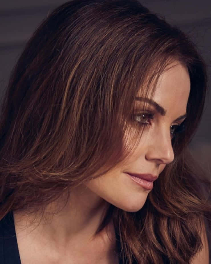Erica Durance, long brown hair, gazing thoughtfully downward, SD Phone Wallpaper