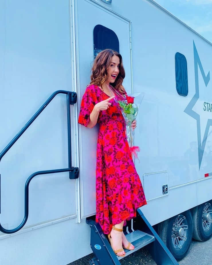 Erin Karpluk, white star-emblazoned trailer, vibrant floral dress, SD Phone Wallpaper
