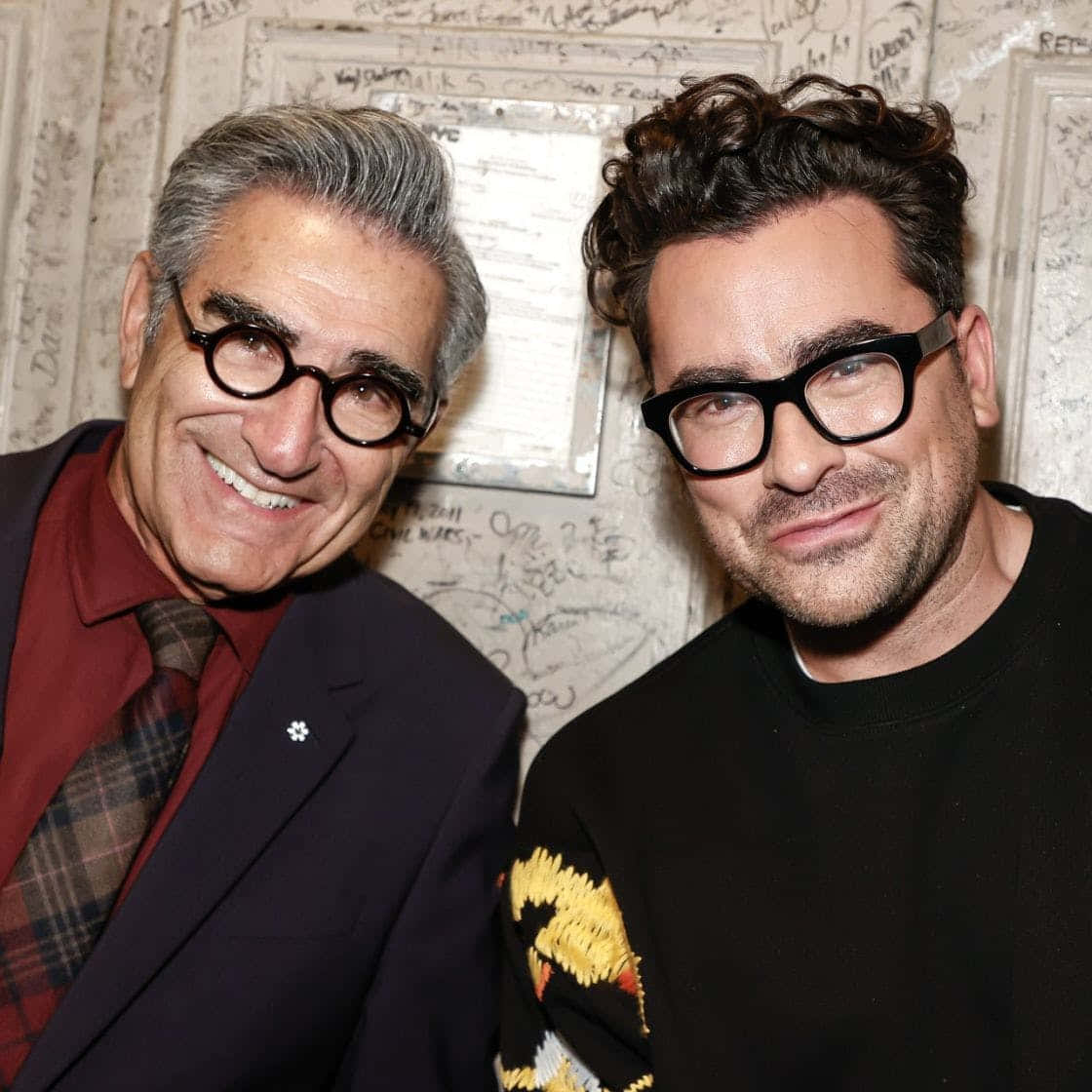 Eugene Levy, thick-rimmed glasses, wall covered in handwritten signatures, SD Desktop Wallpaper