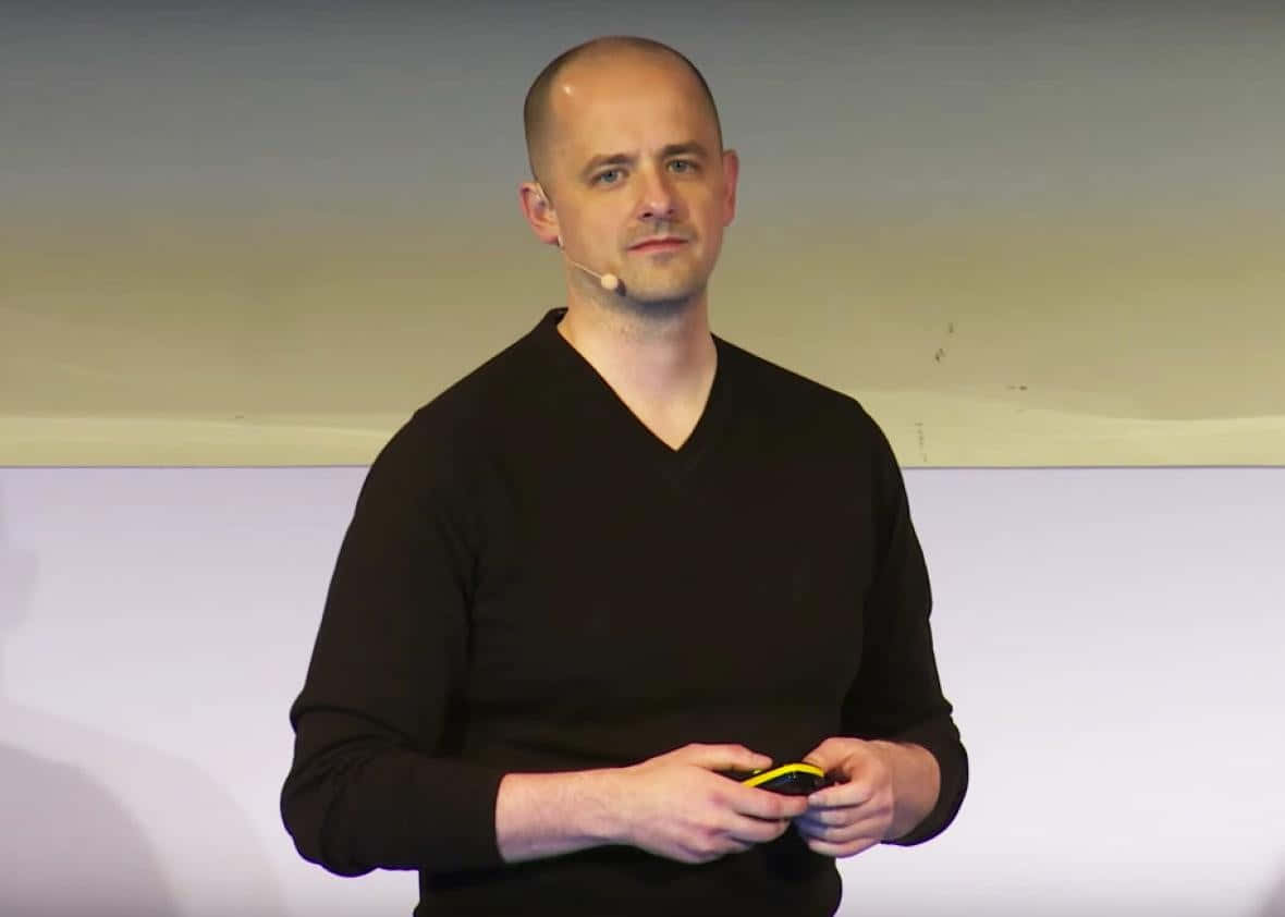 Evan McMullin, black v-neck sweater, yellow remote, SD Desktop Wallpaper