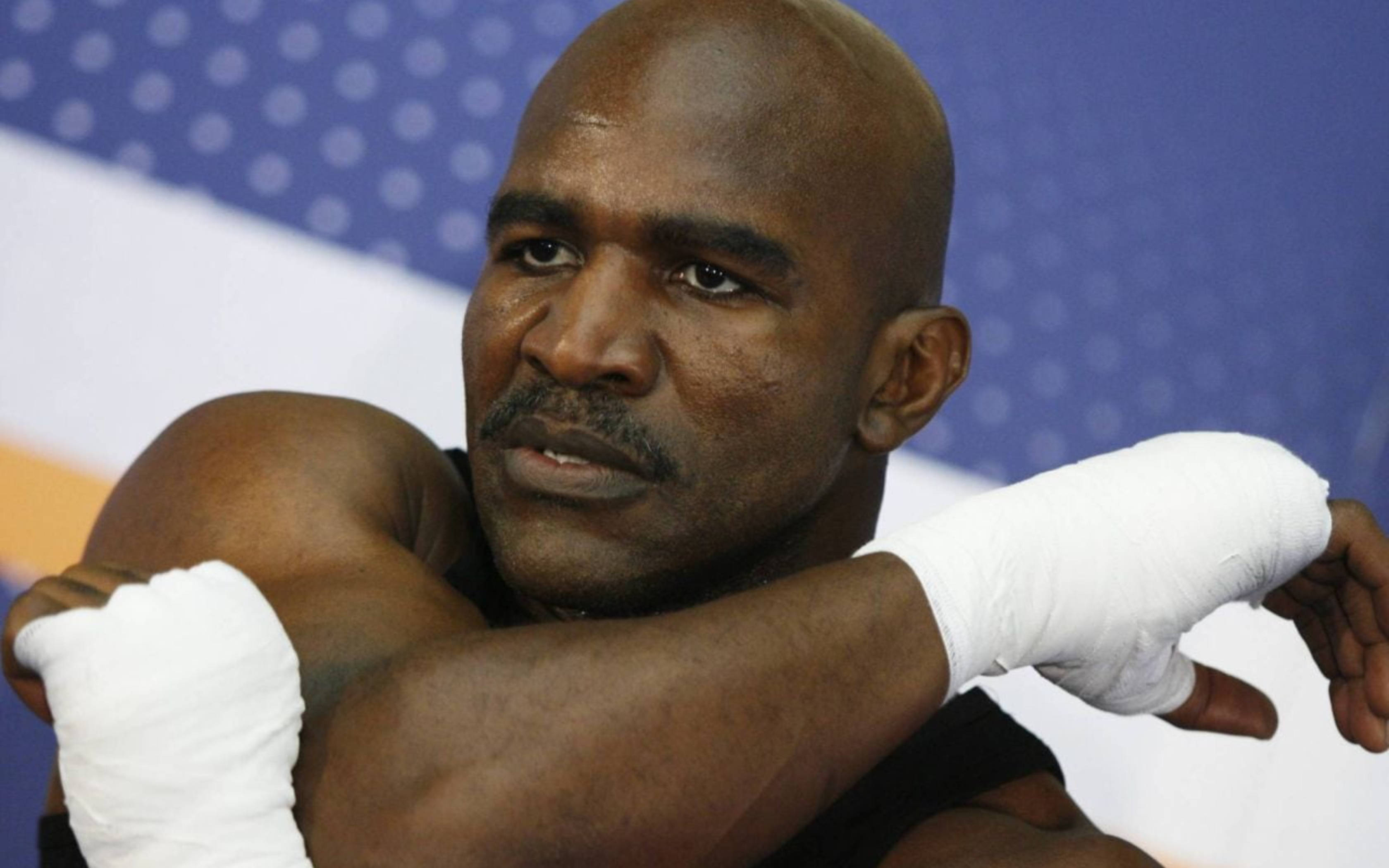 Evander Holyfield, blue and white patterned backdrop, wrapped hands, 2K Desktop Wallpaper