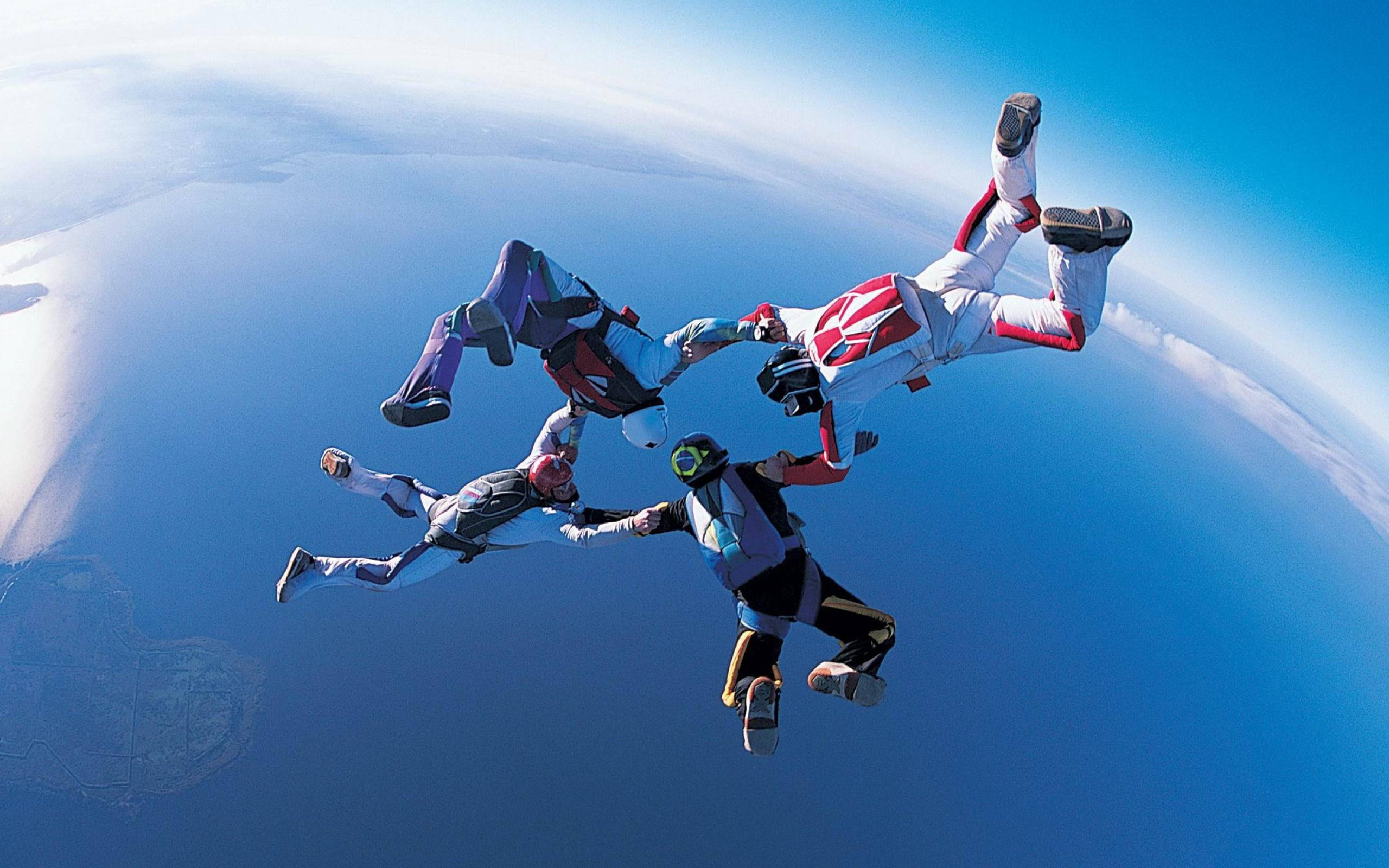 extreme sports skydiving formation, colorful suits, vast blue sky, 2K Desktop Wallpaper