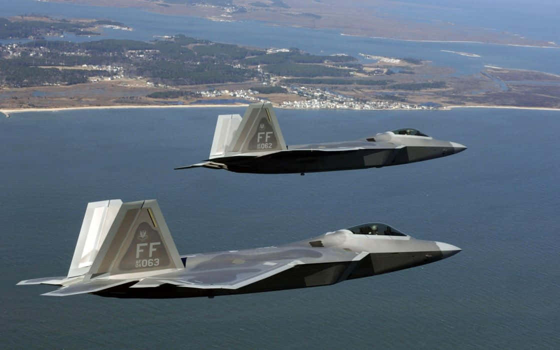 F-22 Raptor, sleek gray fighter jets, coastal landscape, SD Desktop Wallpaper