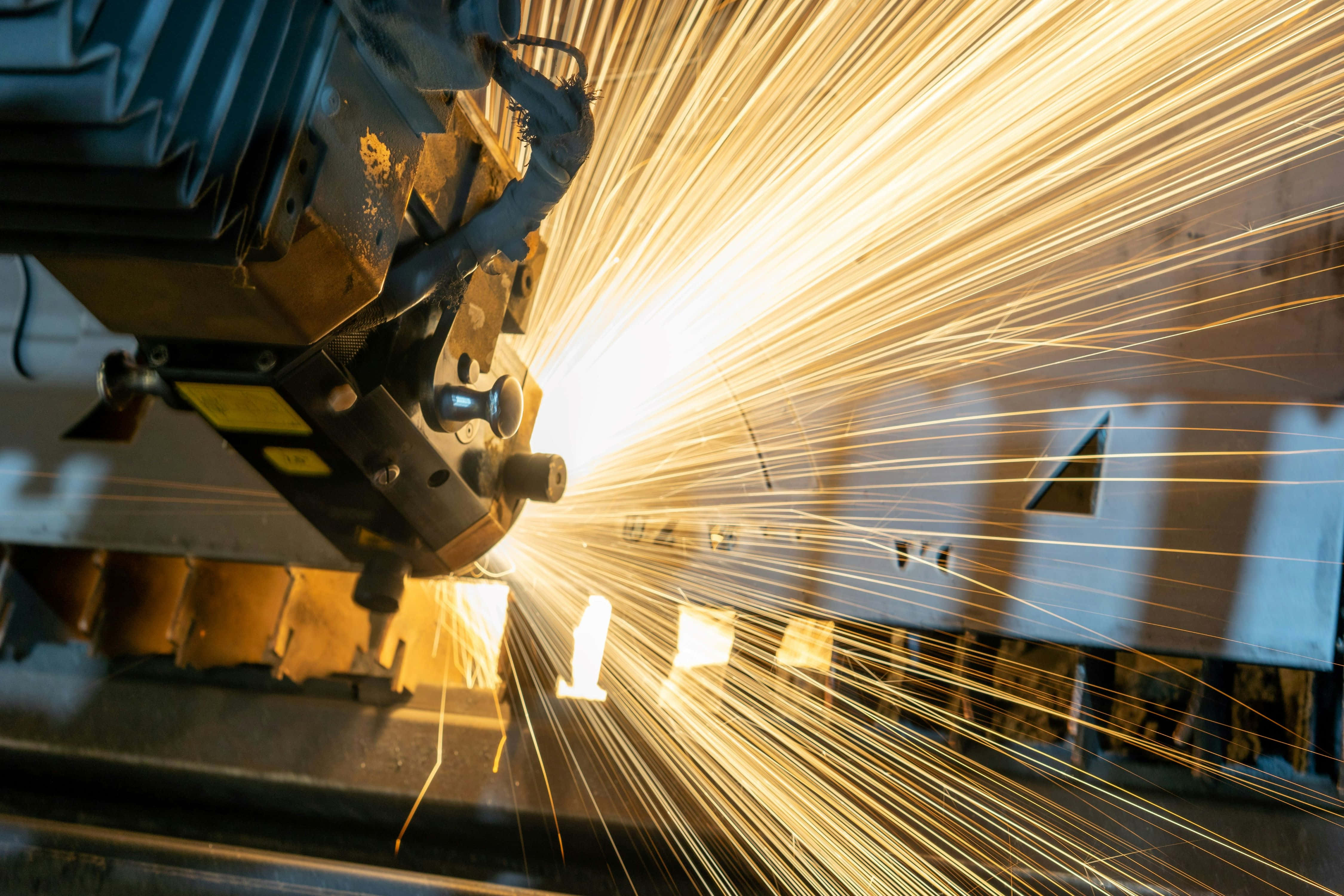metal cutting machine, bright golden sparks, dim industrial workshop, 4K Desktop Wallpaper