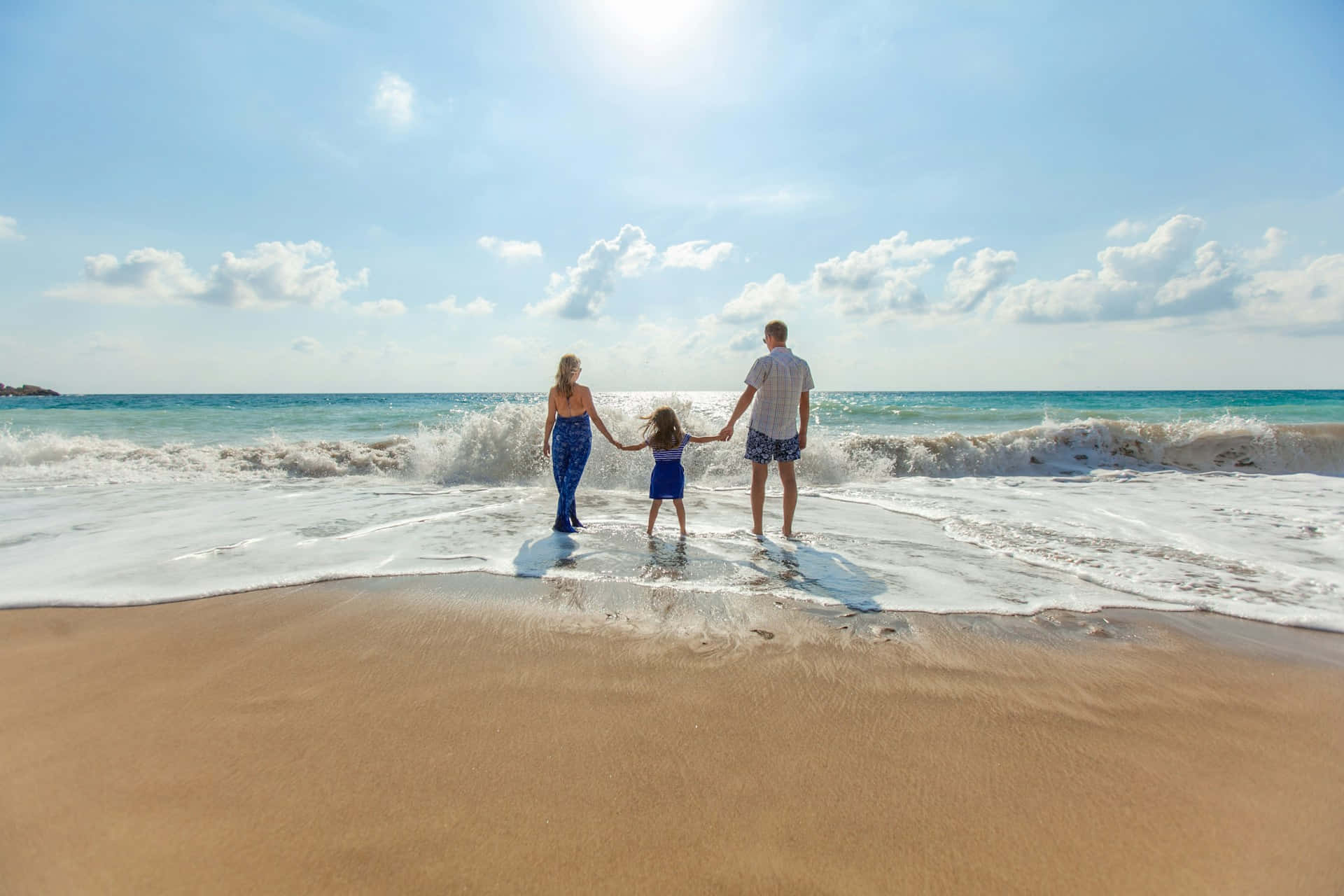 family of three, sunlit beach, waves crash, Full HD Desktop Wallpaper