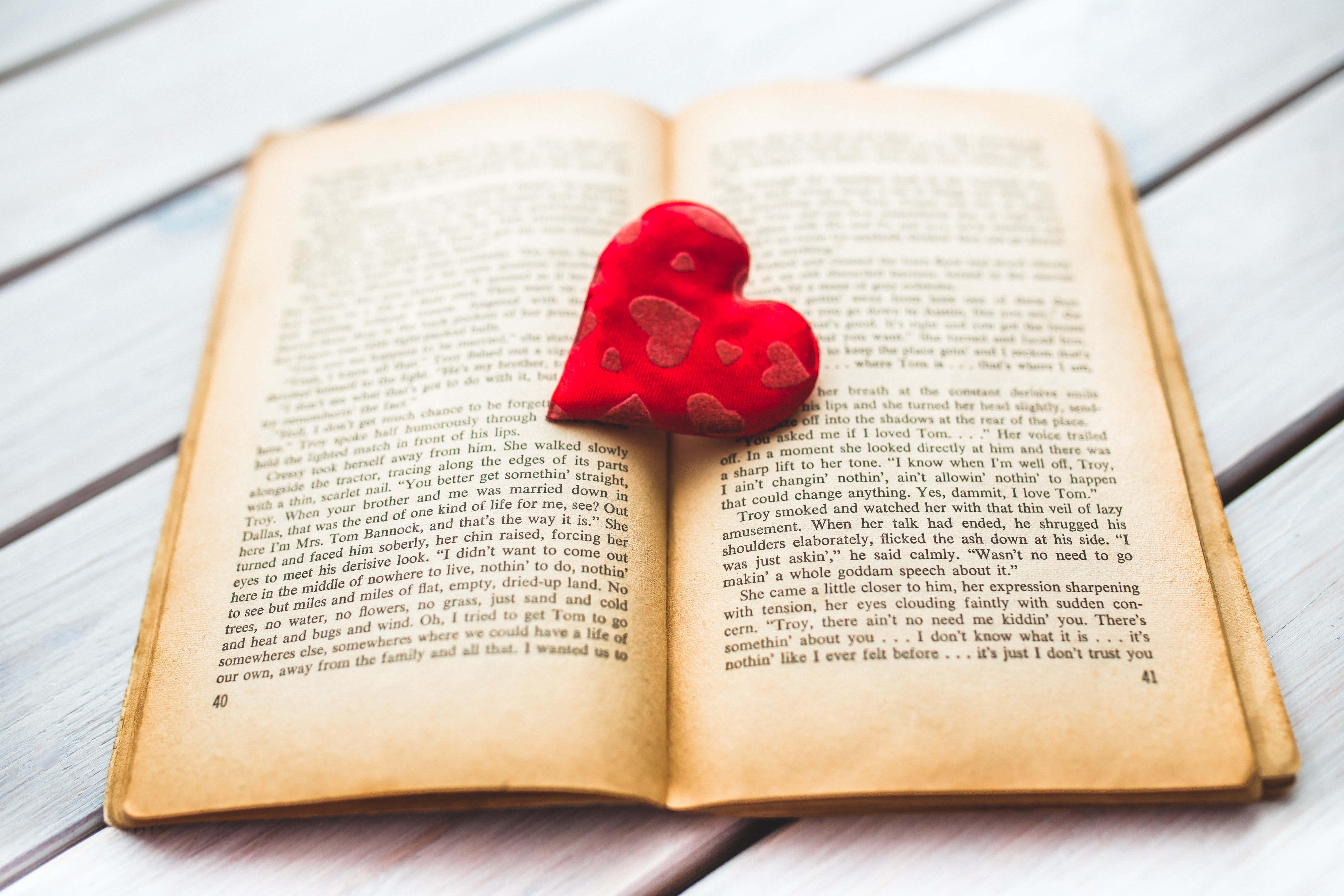 soft red heart-shaped plush toy, vintage book, yellowed paper, 5K Desktop Wallpaper