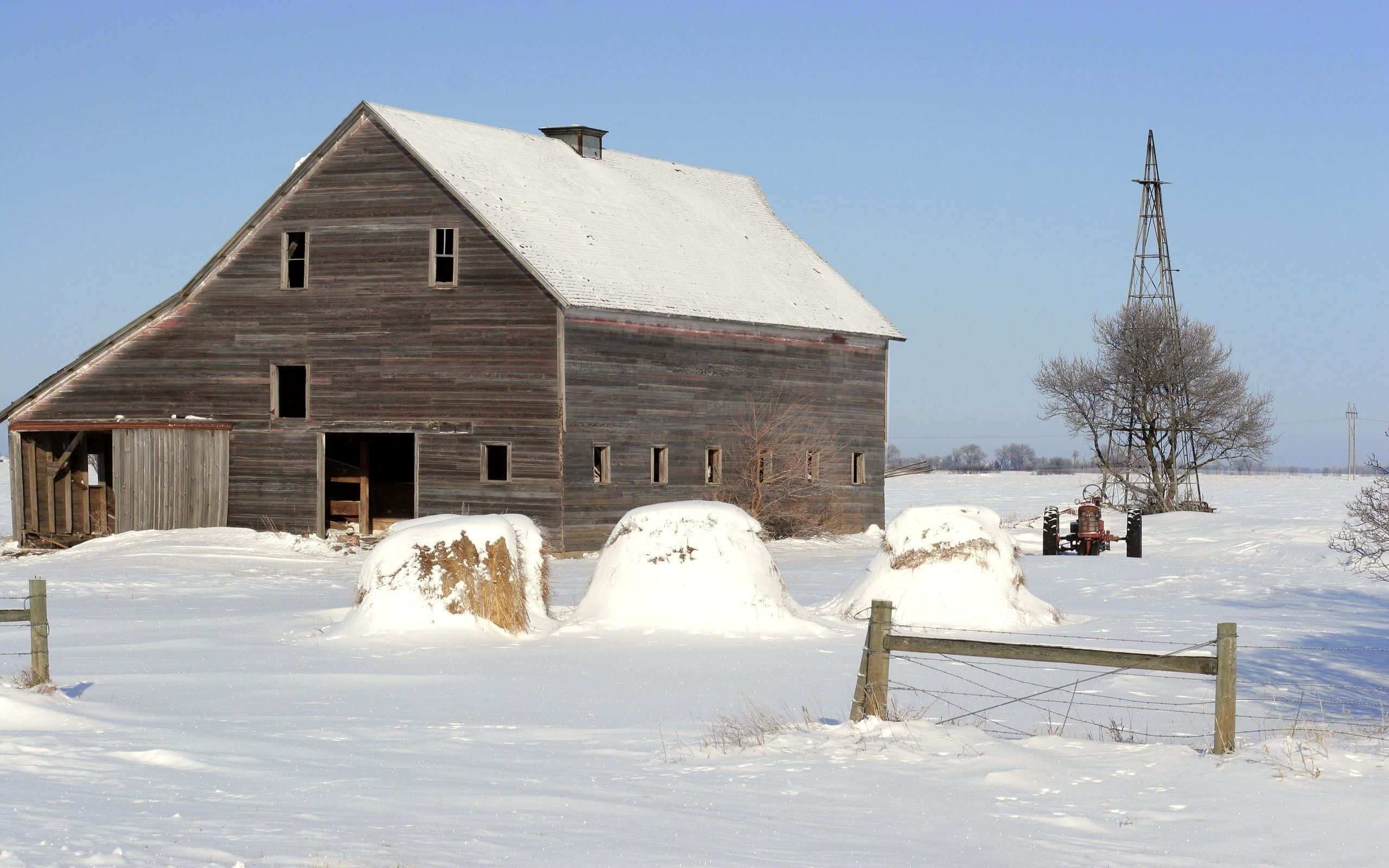 Farmhouse, snow-covered field, hay bales, 2K Desktop Wallpaper
