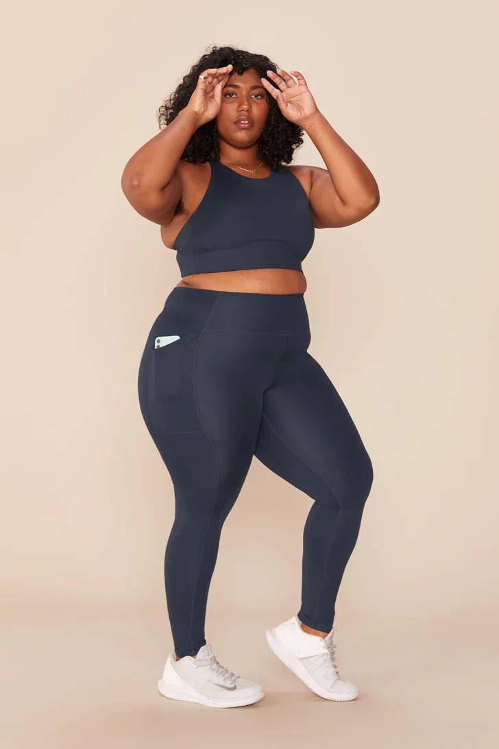navy activewear, soft beige studio backdrop, confident woman, SD Phone Wallpaper