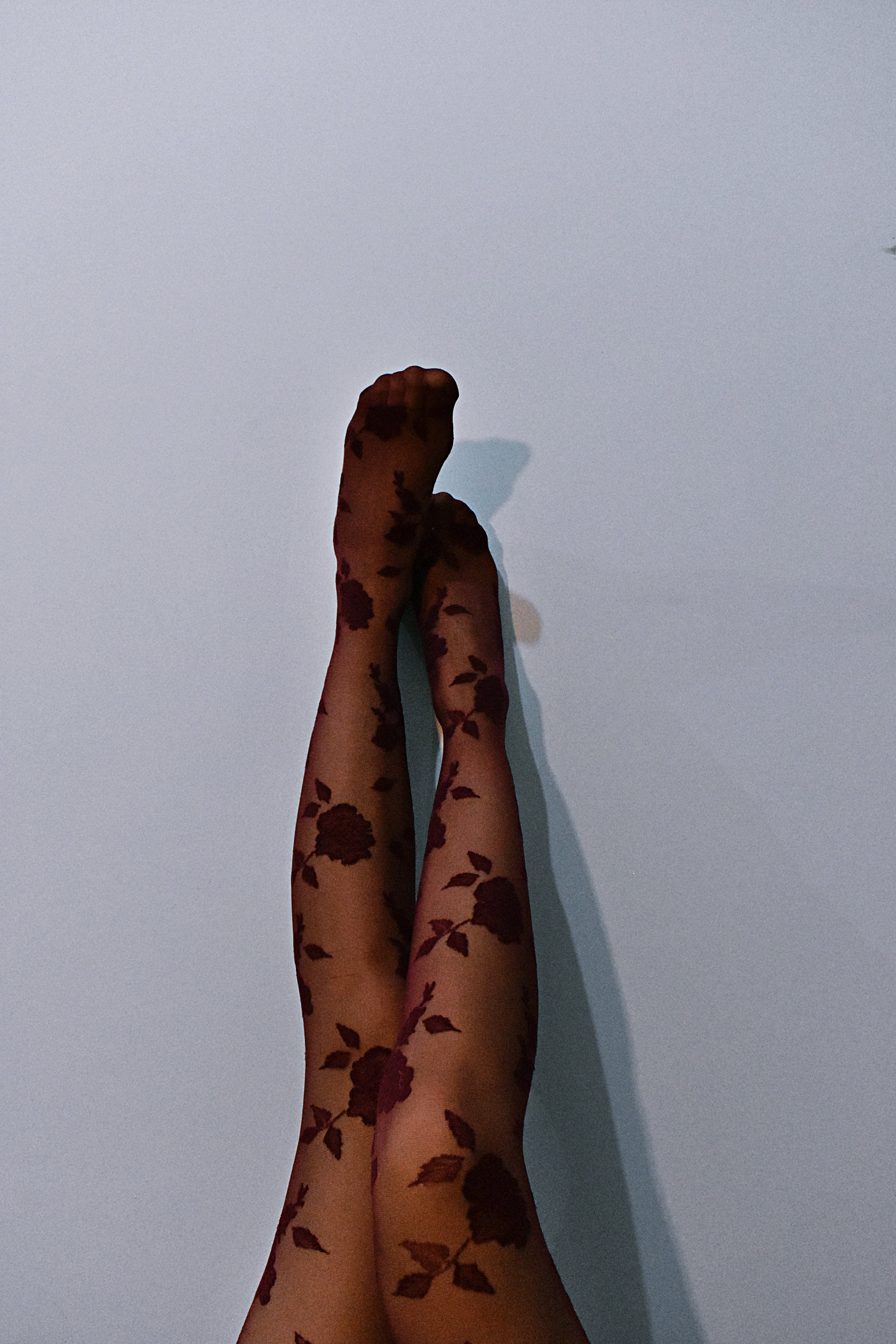 black floral stockings, dark floral patterned tights, light gray wall, 5K Phone Wallpaper