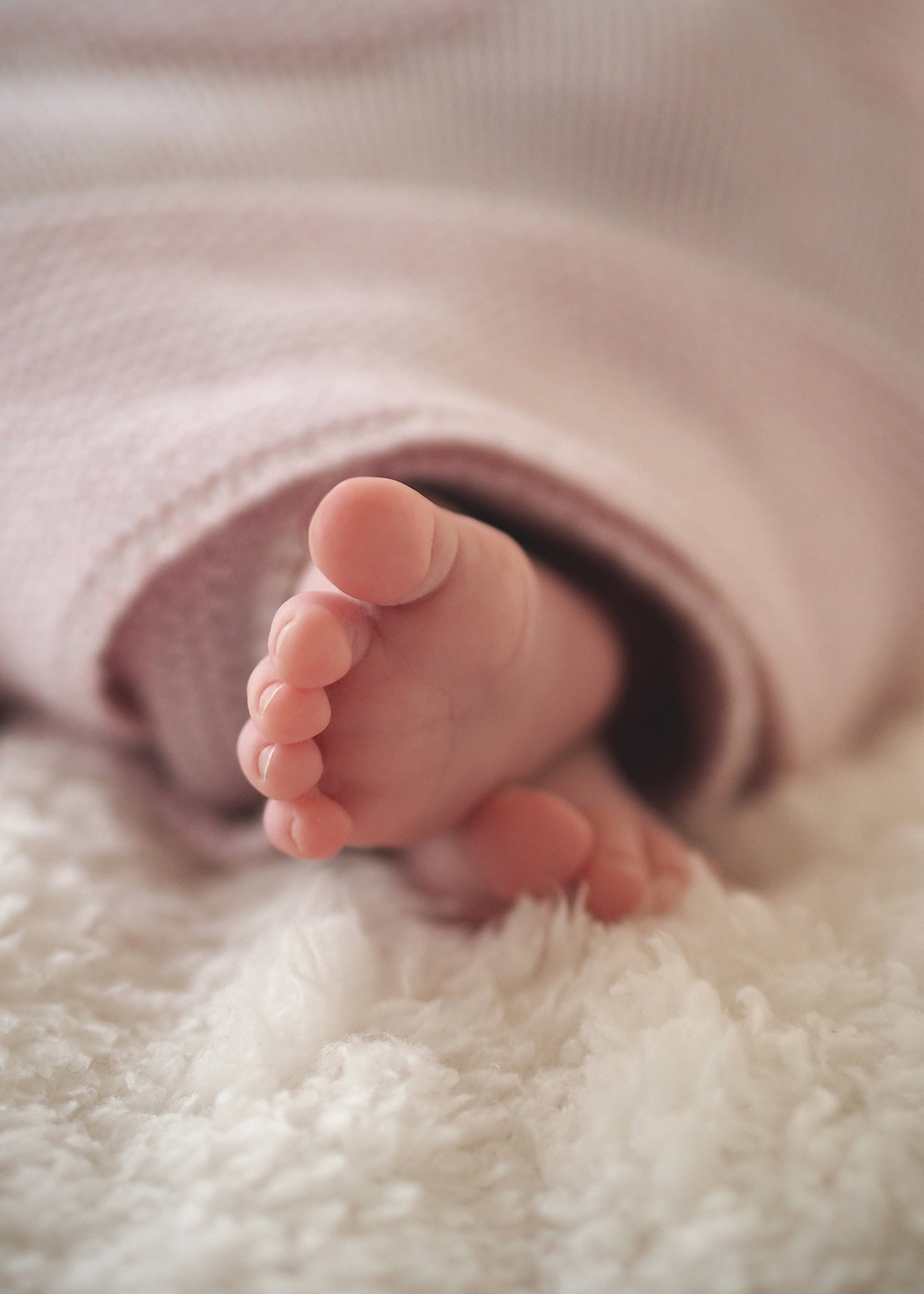 baby's tiny foot, soft pink blanket, fluffy white rug, 2K Phone Wallpaper