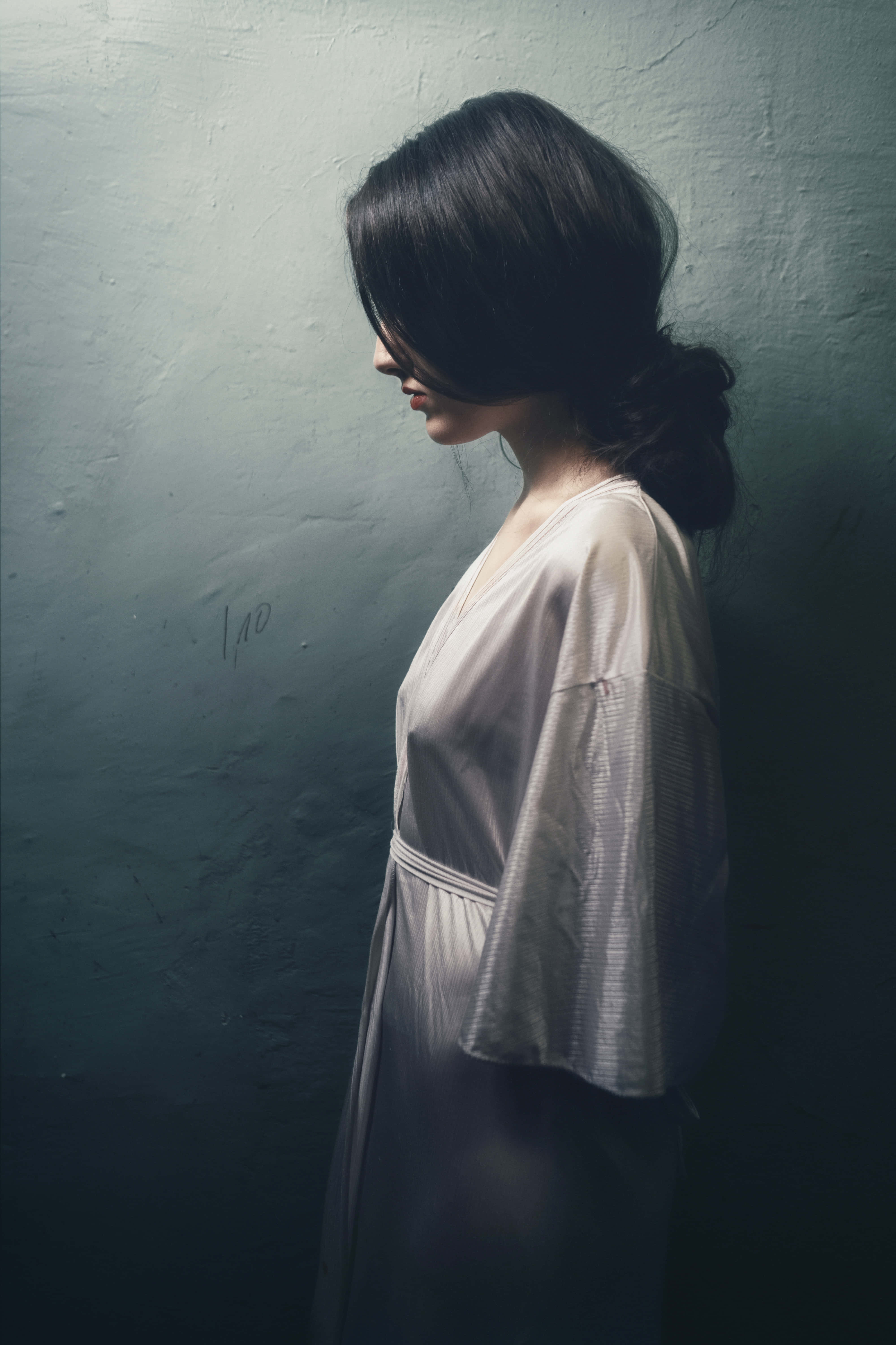 side profile woman, pale robe, textured teal wall, 5K Phone Wallpaper