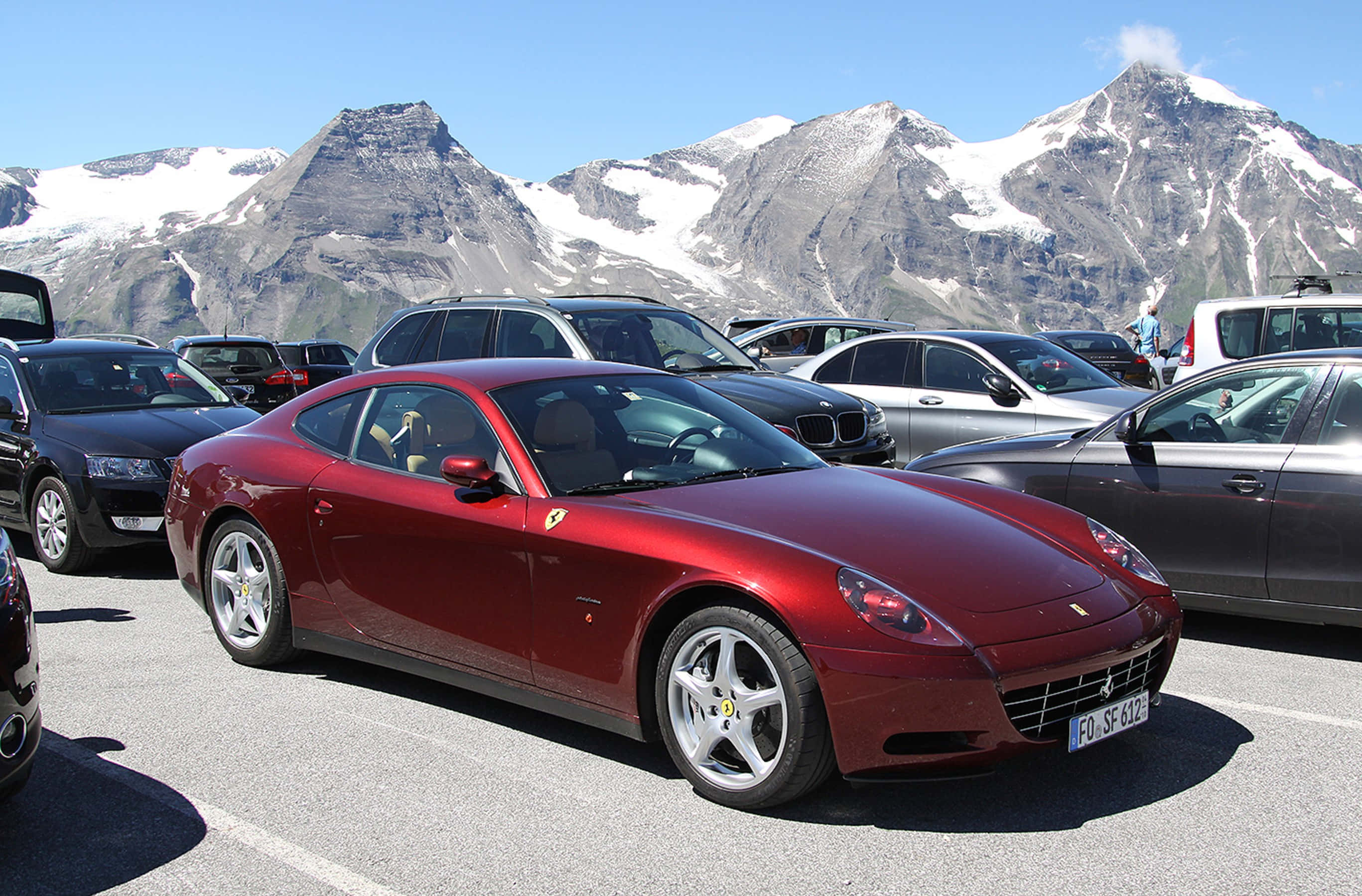 Ferrari 612 Scaglietti, glossy red, mountainous alpine parking lot, 2K Desktop Wallpaper