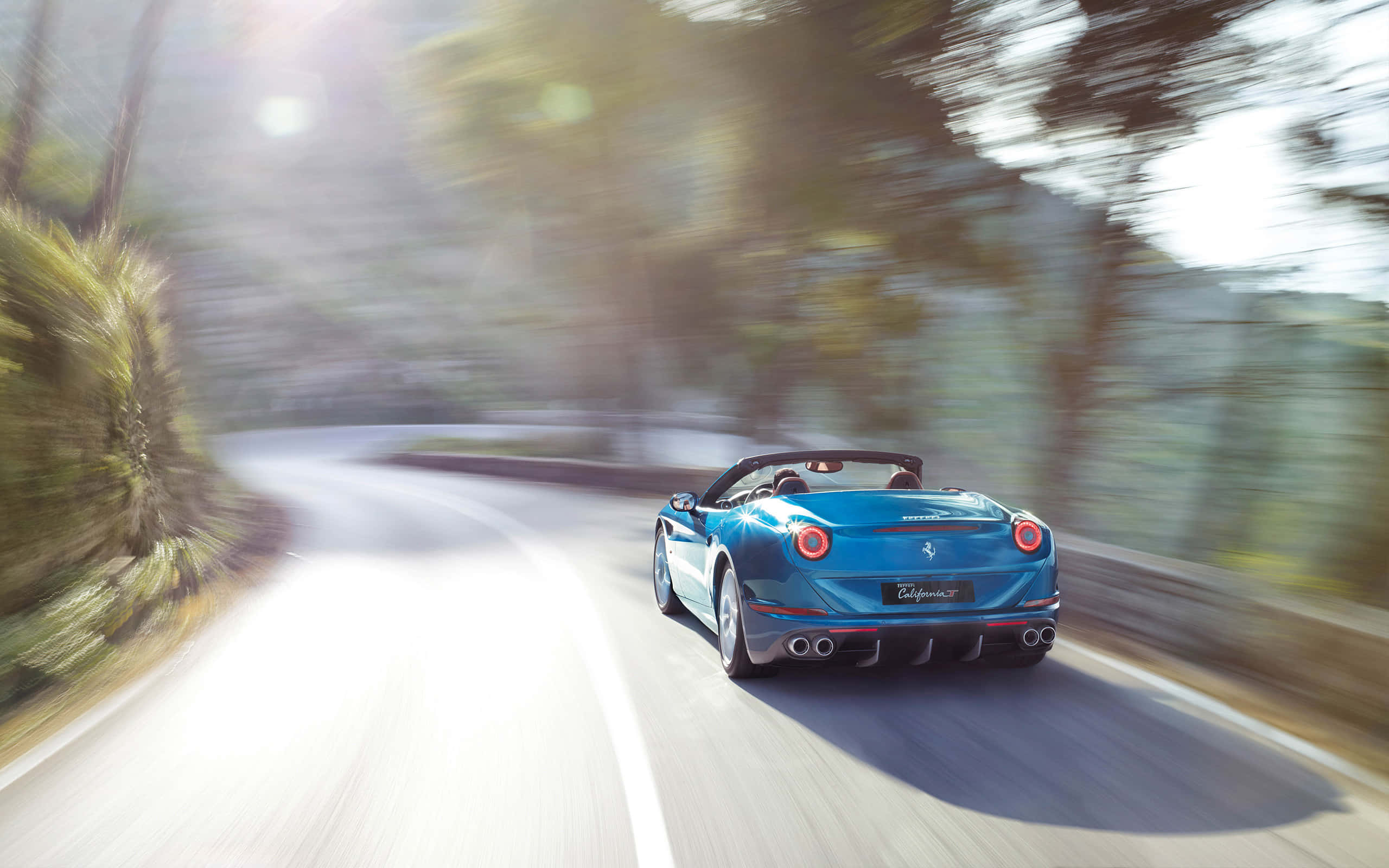Ferrari California T, vibrant blue, winding forest road, 2K Desktop Wallpaper