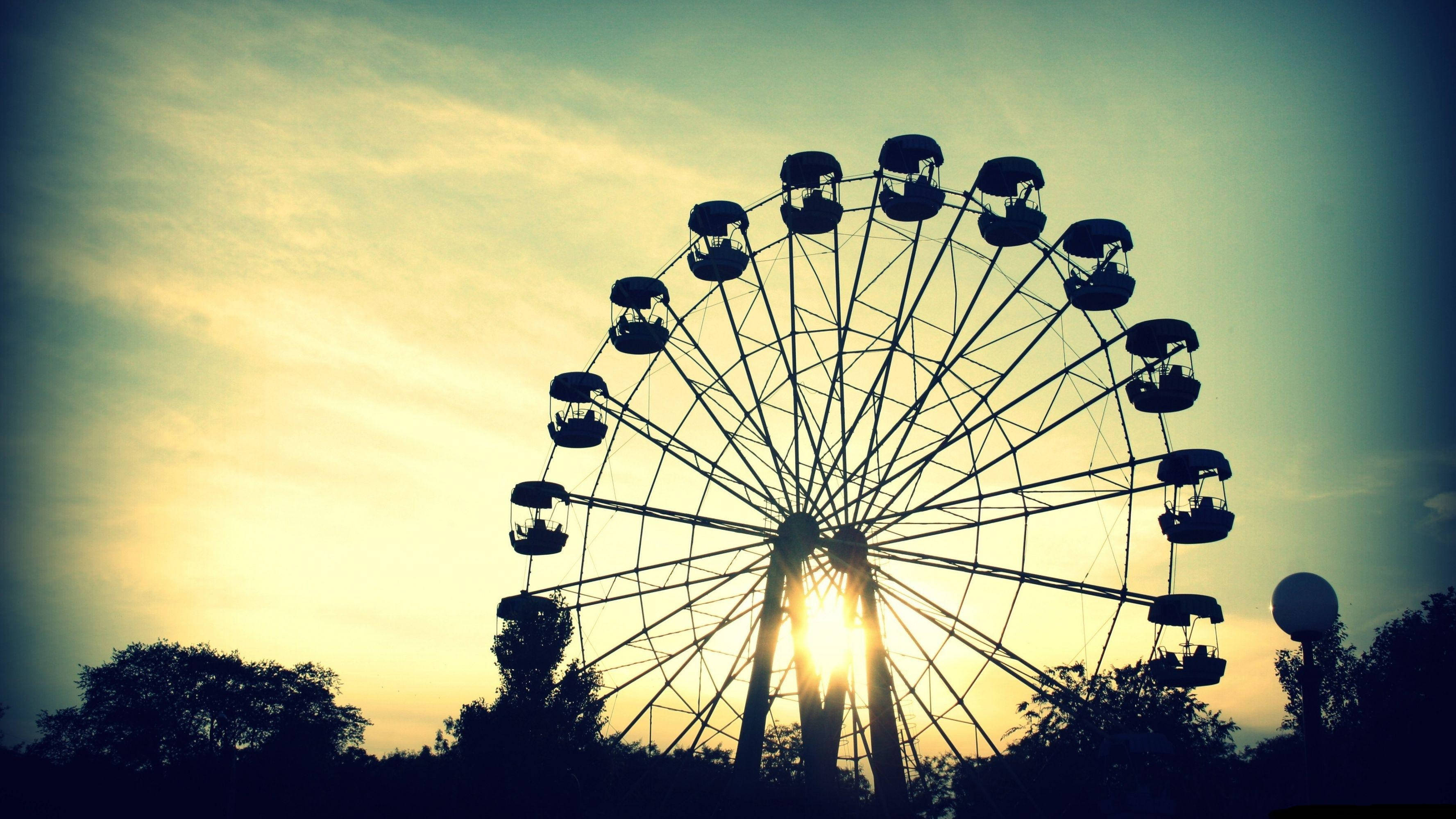 Ferris wheel, golden sunset sky, warm light, 2K Desktop Wallpaper