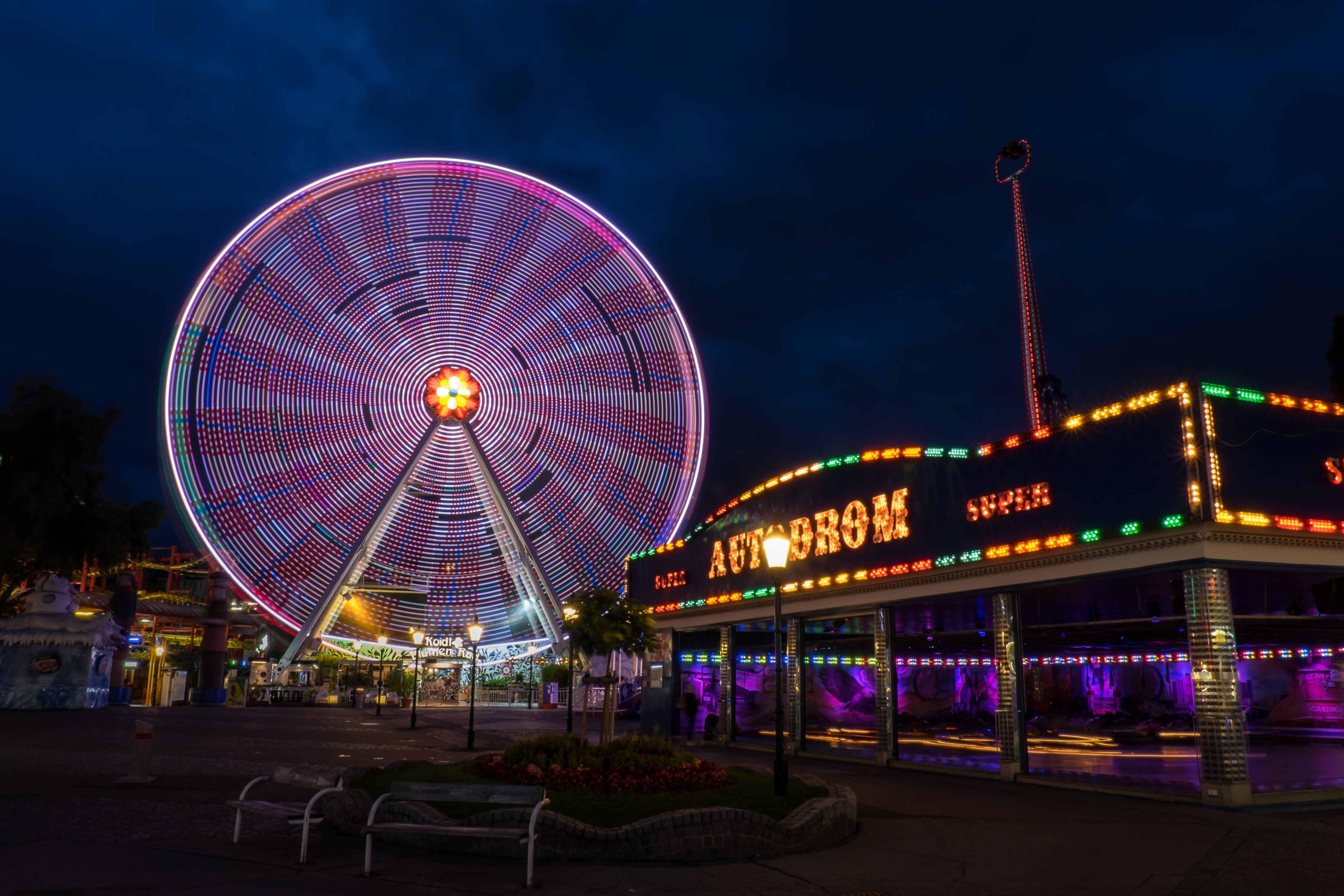 Ferris wheel, neon-lit amusement park building, deep blue night sky, 4K Desktop Wallpaper