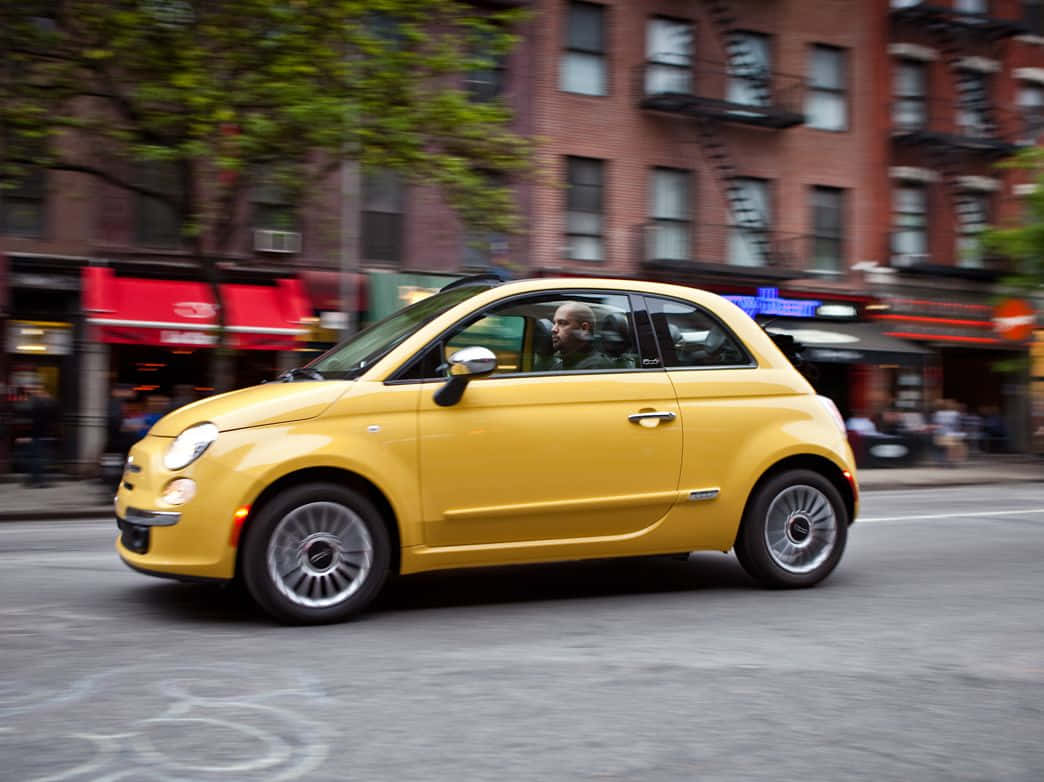 Fiat 500, bright yellow, bustling city street, SD Desktop Wallpaper