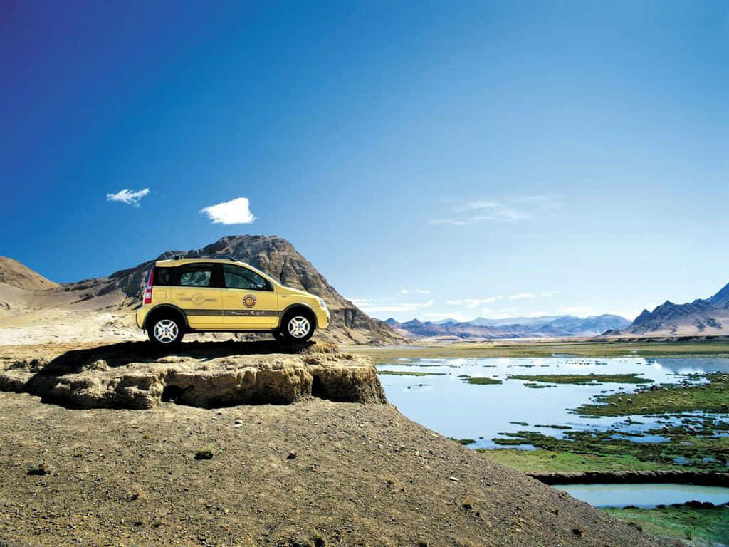 Fiat Panda, bright yellow, rocky outcrop, SD Desktop Wallpaper