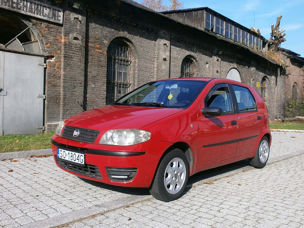 Fiat Punto, vibrant red, cobblestone street, SD Desktop Wallpaper