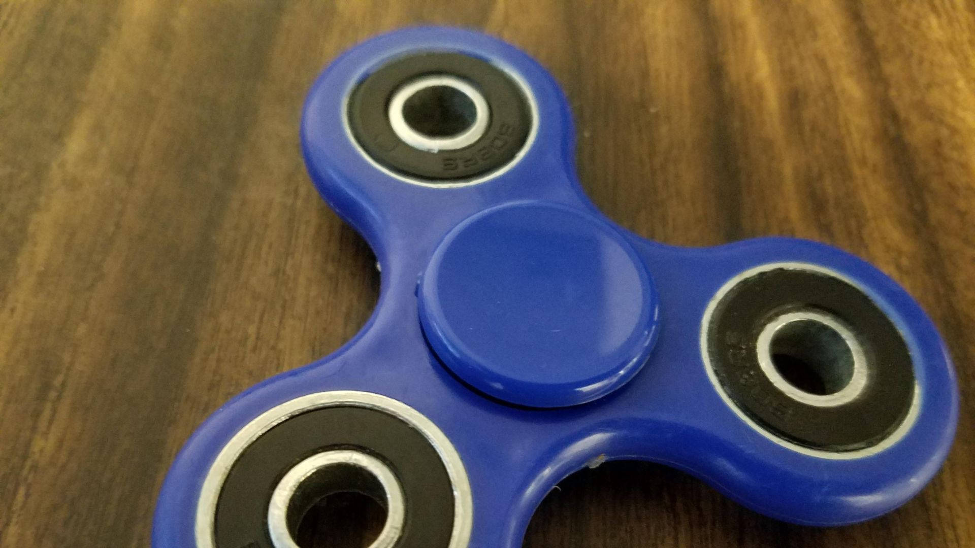 fidget spinner, vibrant blue, warm wooden surface, Full HD Desktop Wallpaper