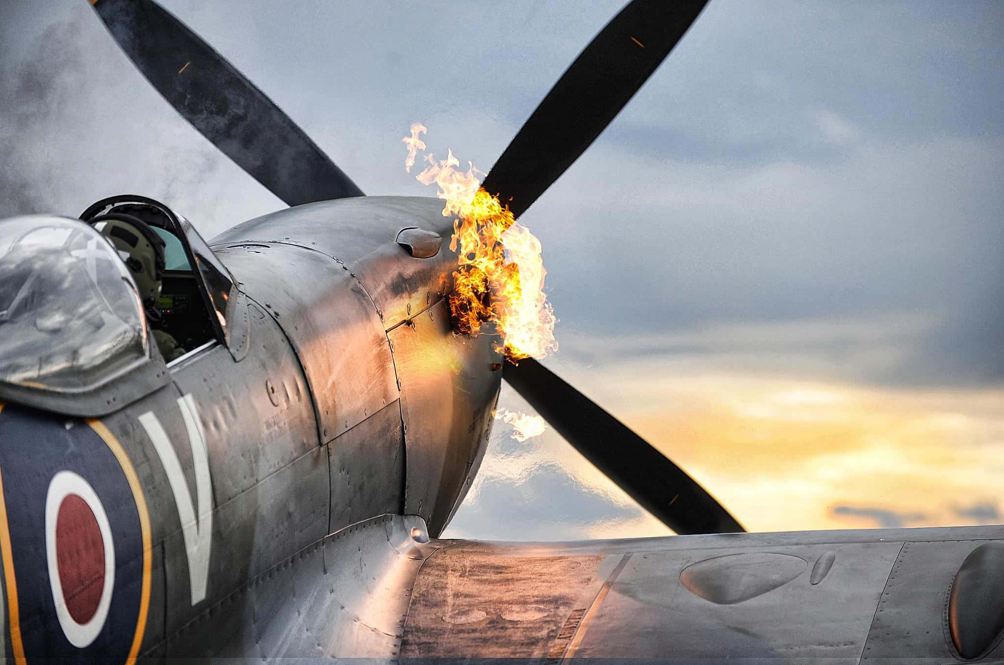 vintage fighter plane, flames erupting from its propeller, dramatic sunset sky, Full HD Desktop Wallpaper