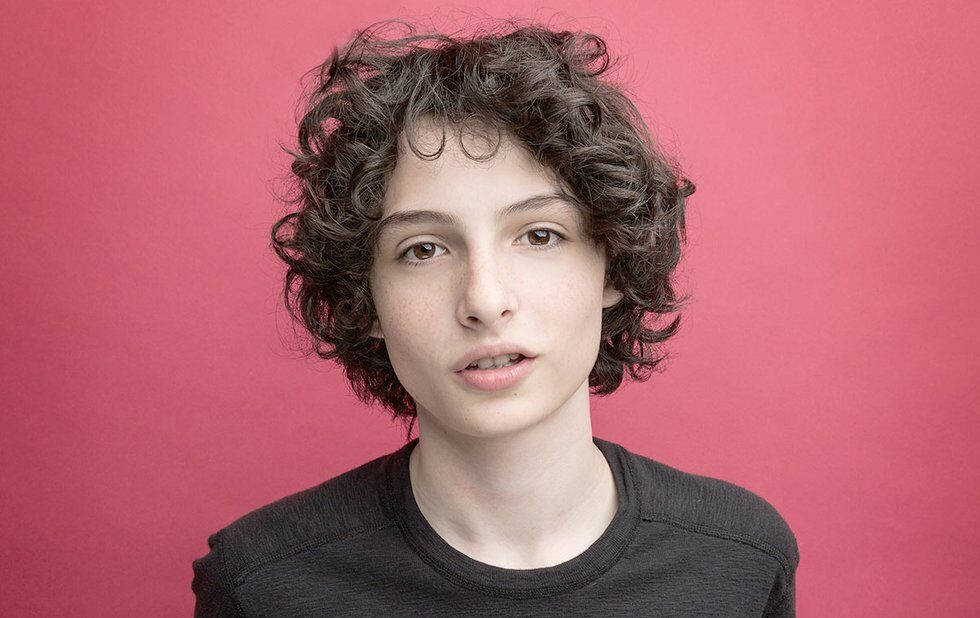 Finn Wolfhard, curly dark hair, solid pink background, SD Desktop Wallpaper