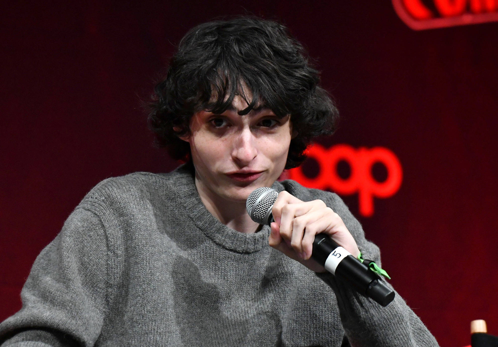 Finn Wolfhard, red backdrop, microphone, Full HD Desktop Wallpaper