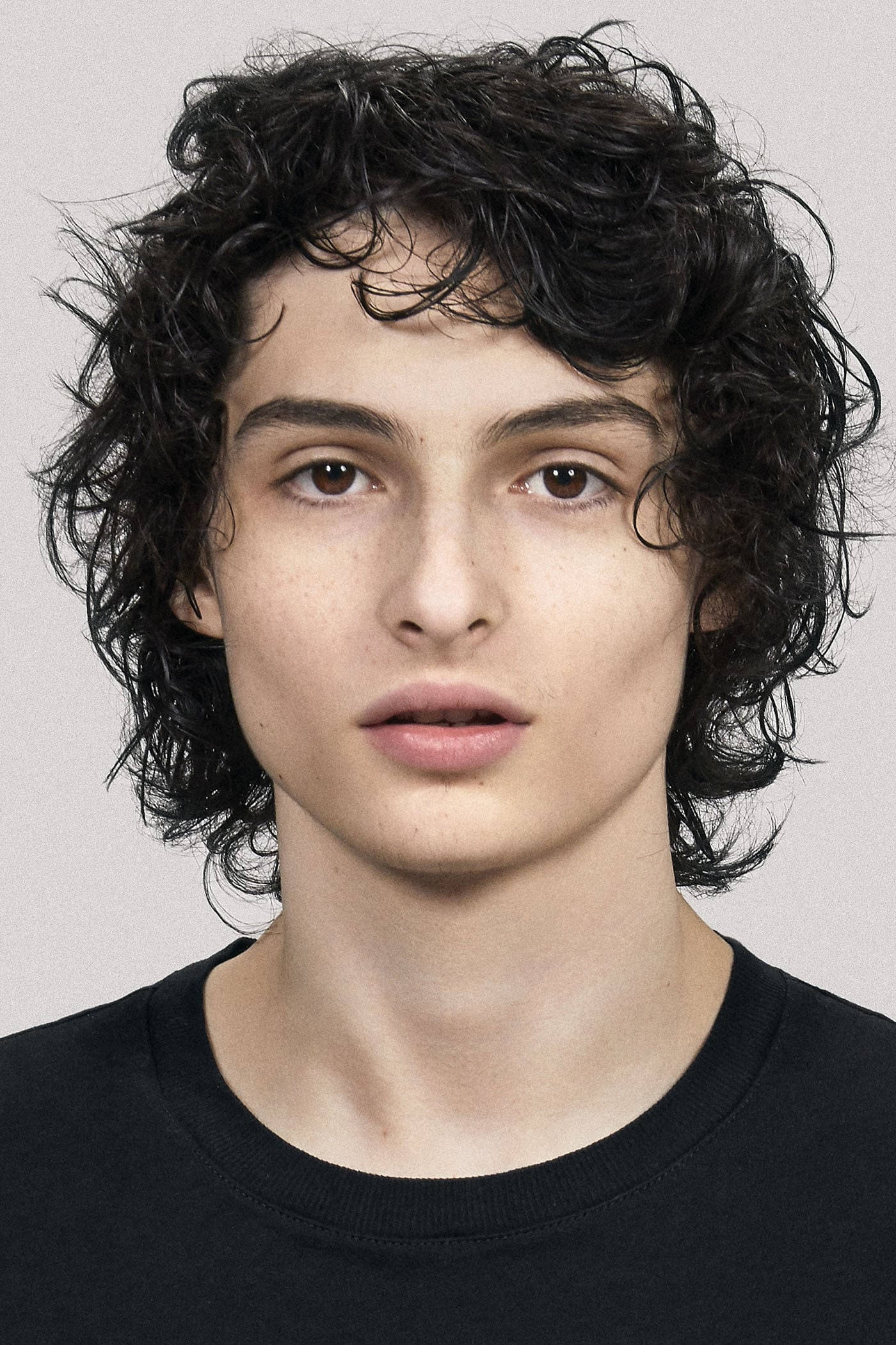 Finn Wolfhard, dark curly hair, neutral expression, Full HD Phone Wallpaper