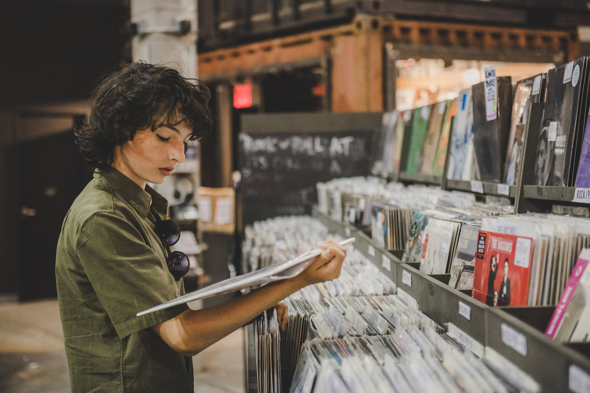 Finn Wolfhard, vinyl records, dimly lit record store, Full HD Desktop Wallpaper