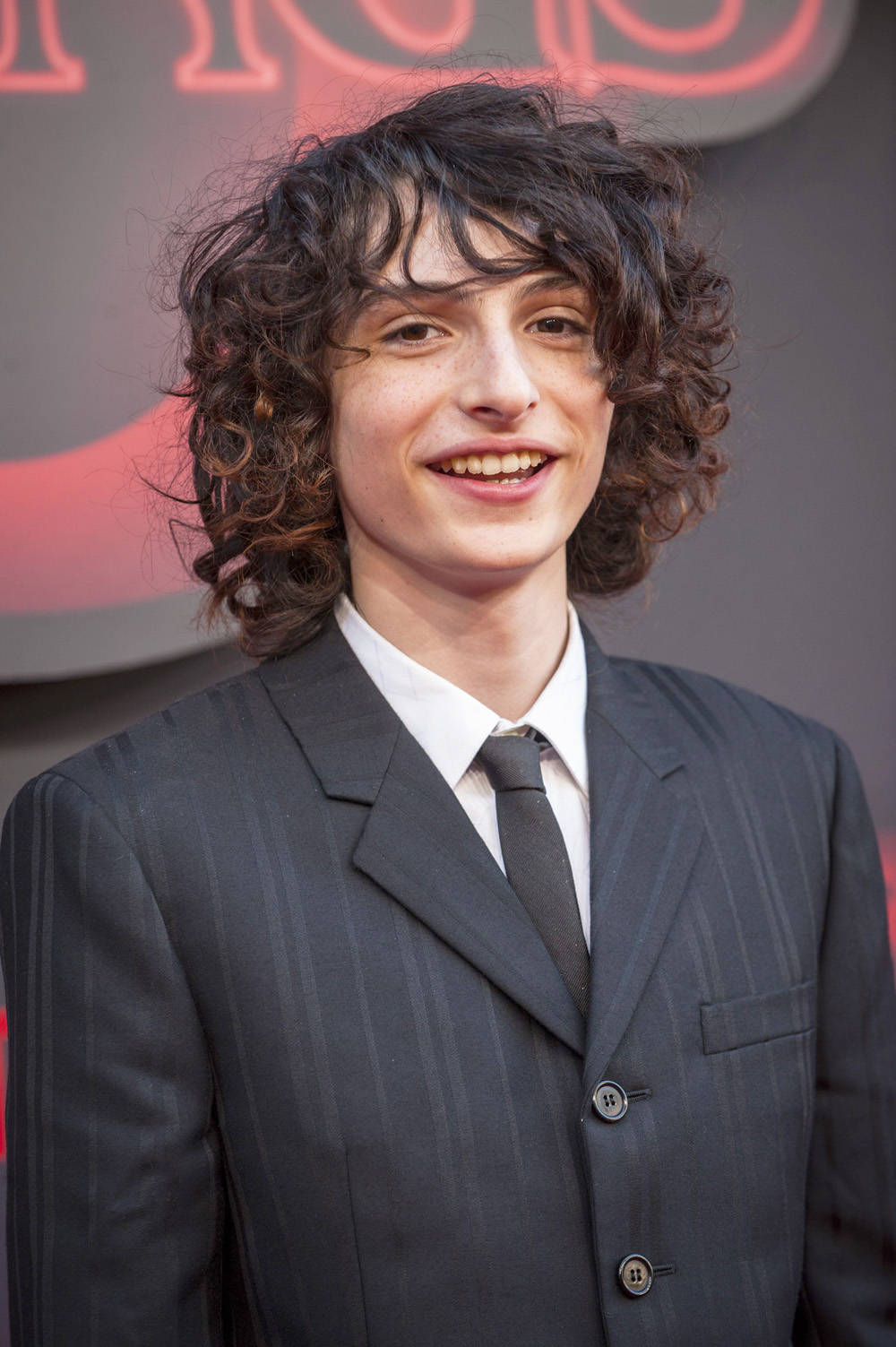 Finn Wolfhard, pinstripe suit, red logo backdrop, HD Phone Wallpaper