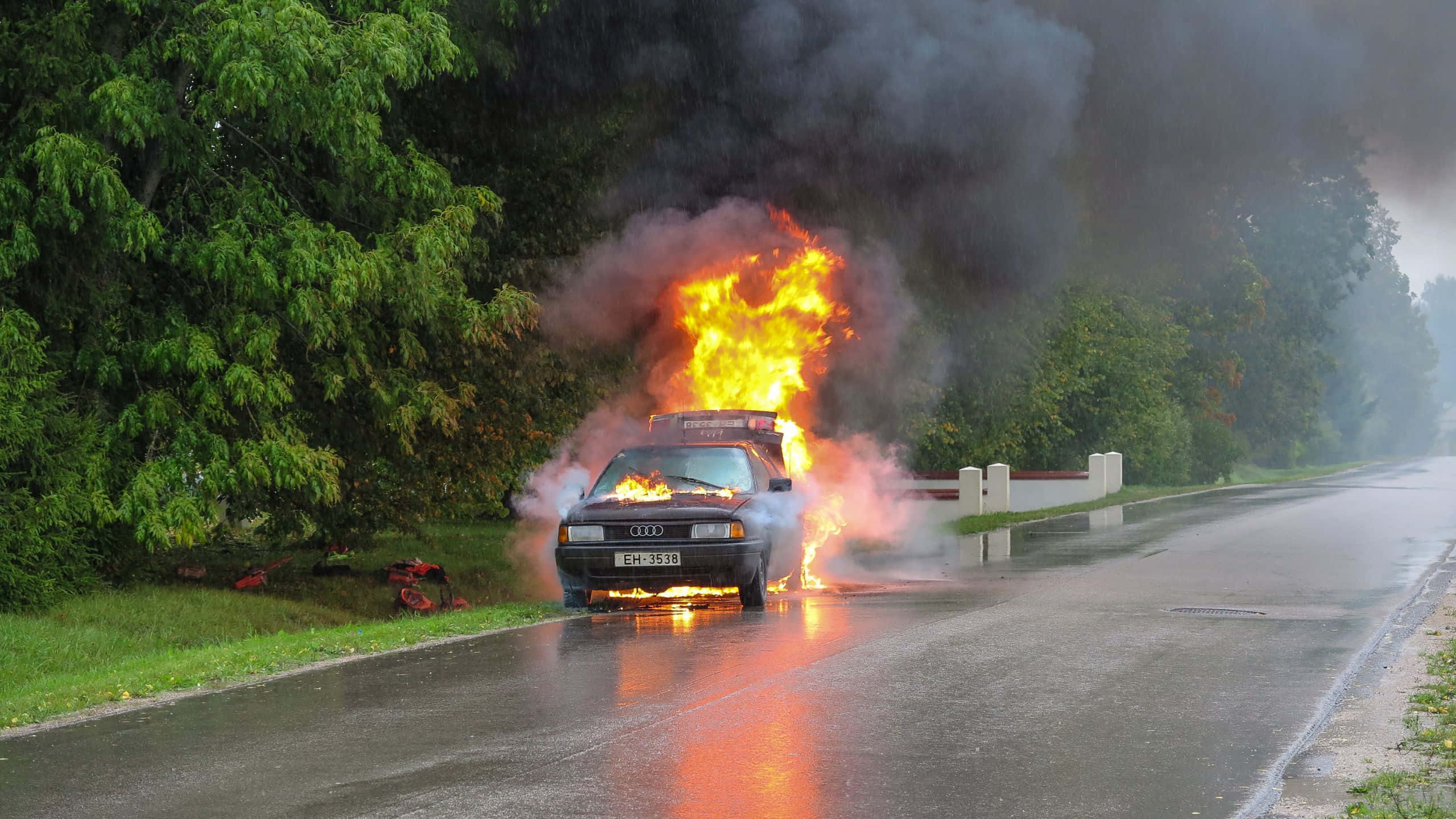 car on fire, wet roadside, thick black smoke, 2K Desktop Wallpaper