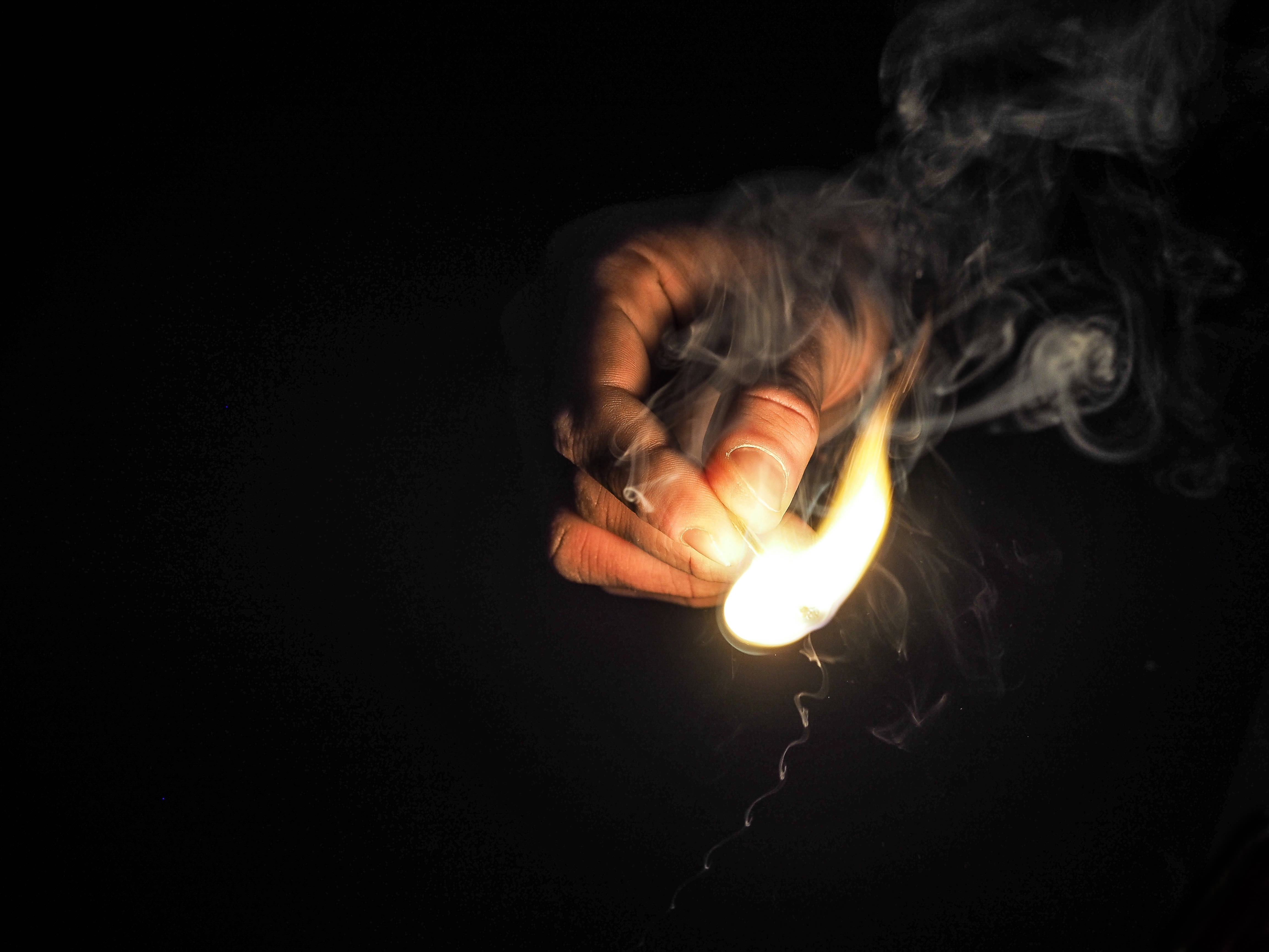 hand, glowing match, black background, 4K Desktop Wallpaper