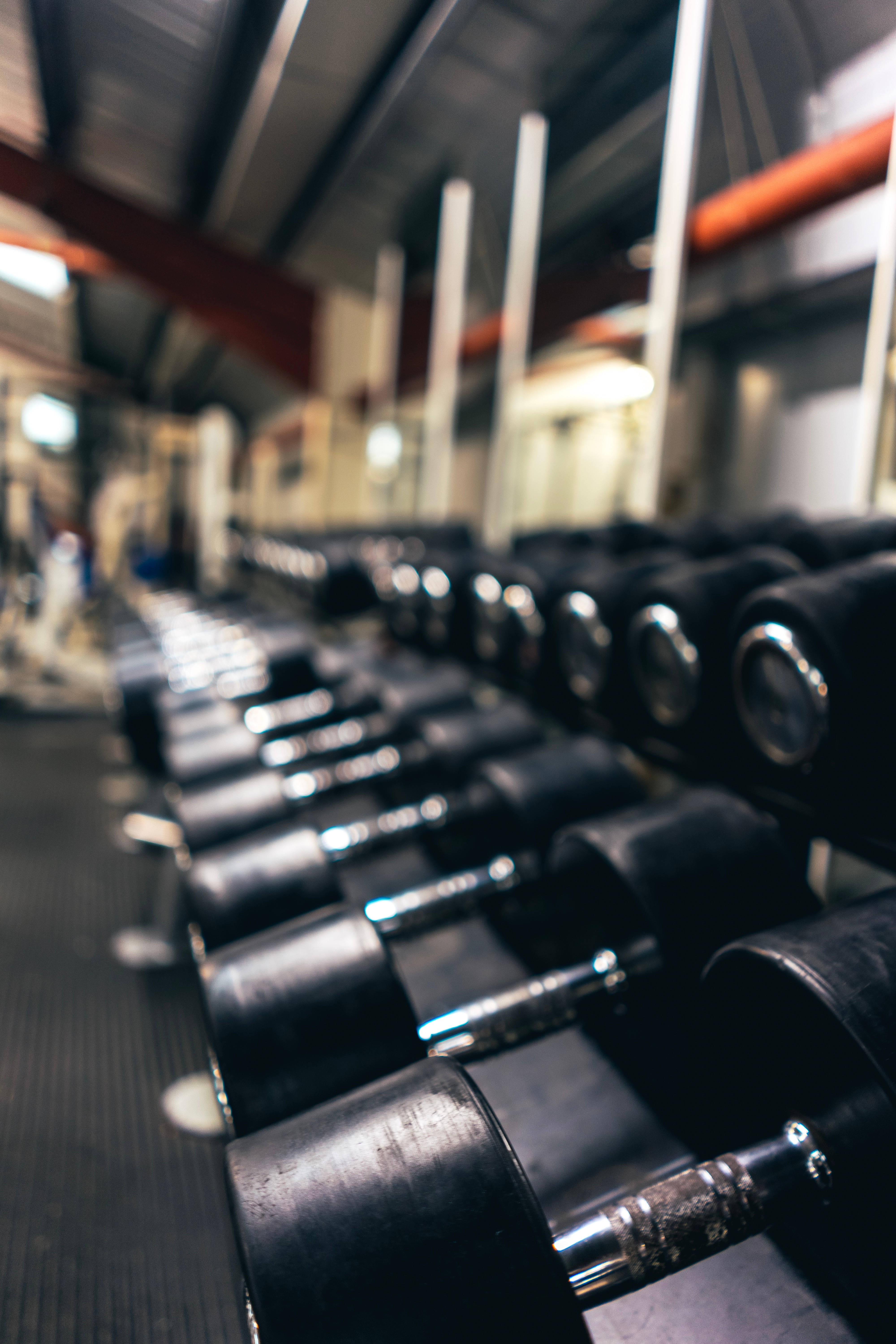 black cascading fitness dumbbells, gym lights, shallow depth of field, 5K Phone Wallpaper
