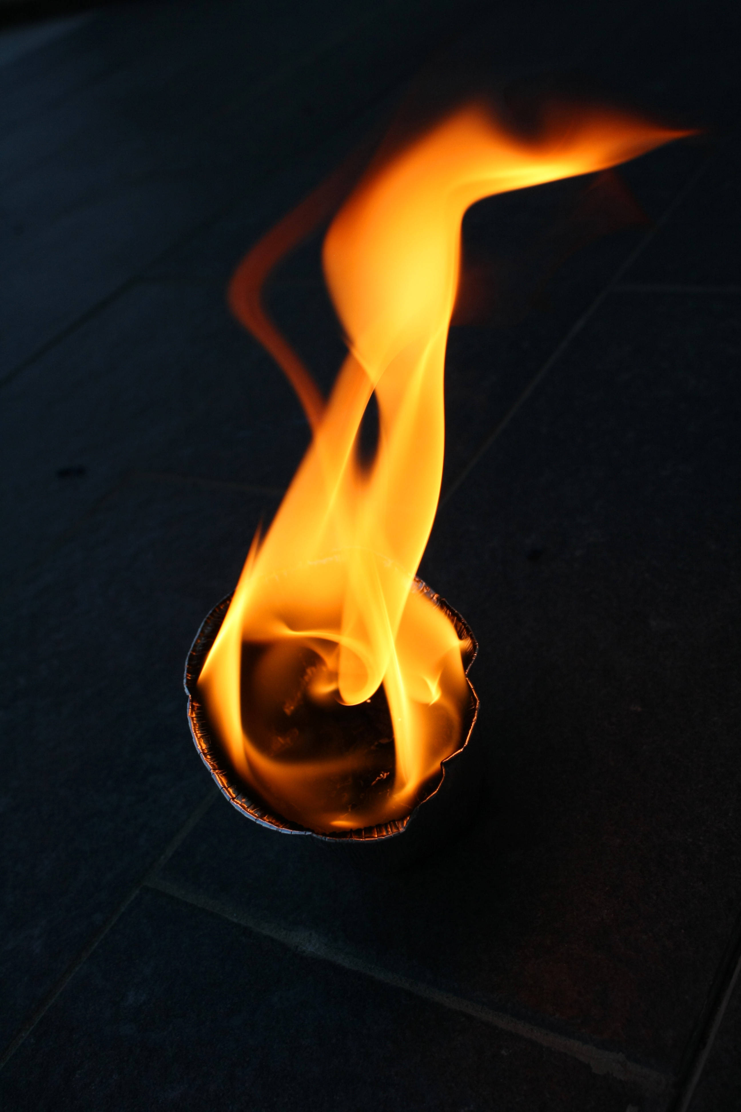orange flame, small metal cup, dark tiled floor, 4K Phone Wallpaper