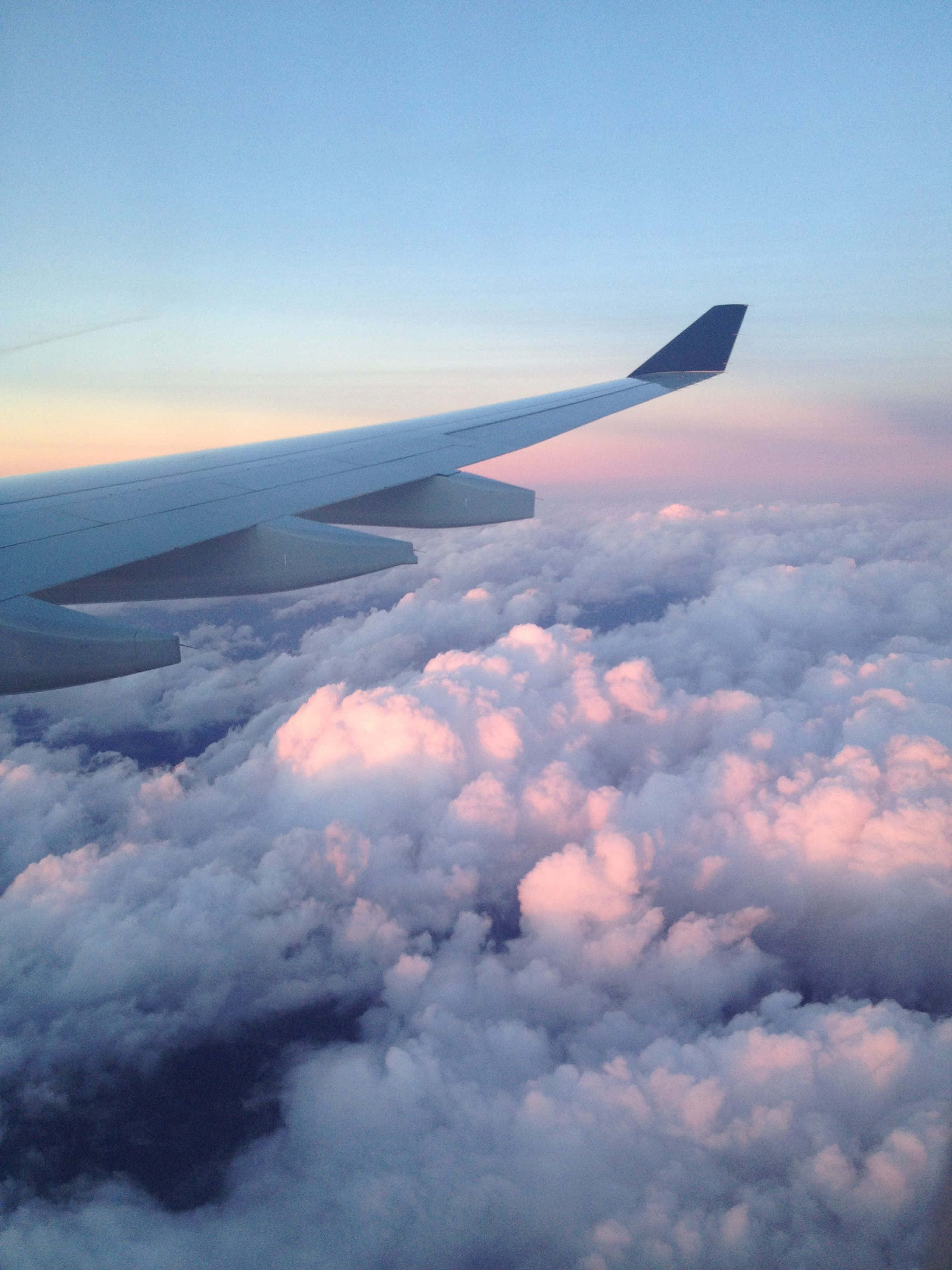 airplane wing, sea of fluffy clouds, soft pink and blue twilight hues, 2K Phone Wallpaper