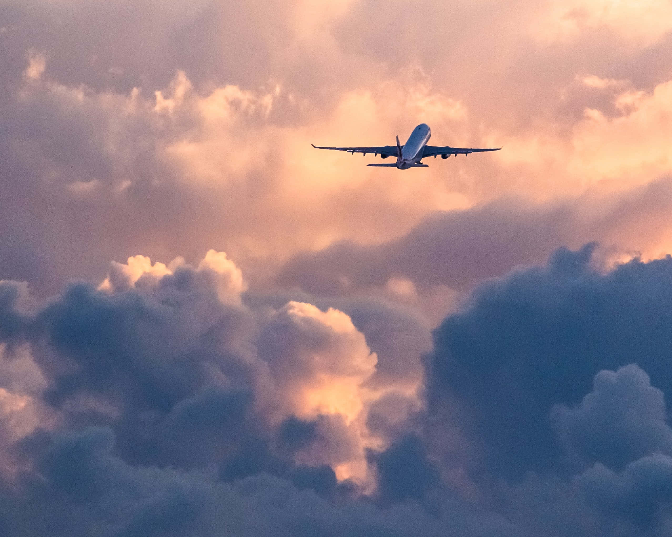 commercial airplane, dramatic clouds, warm sunset hues, Full HD Desktop Wallpaper