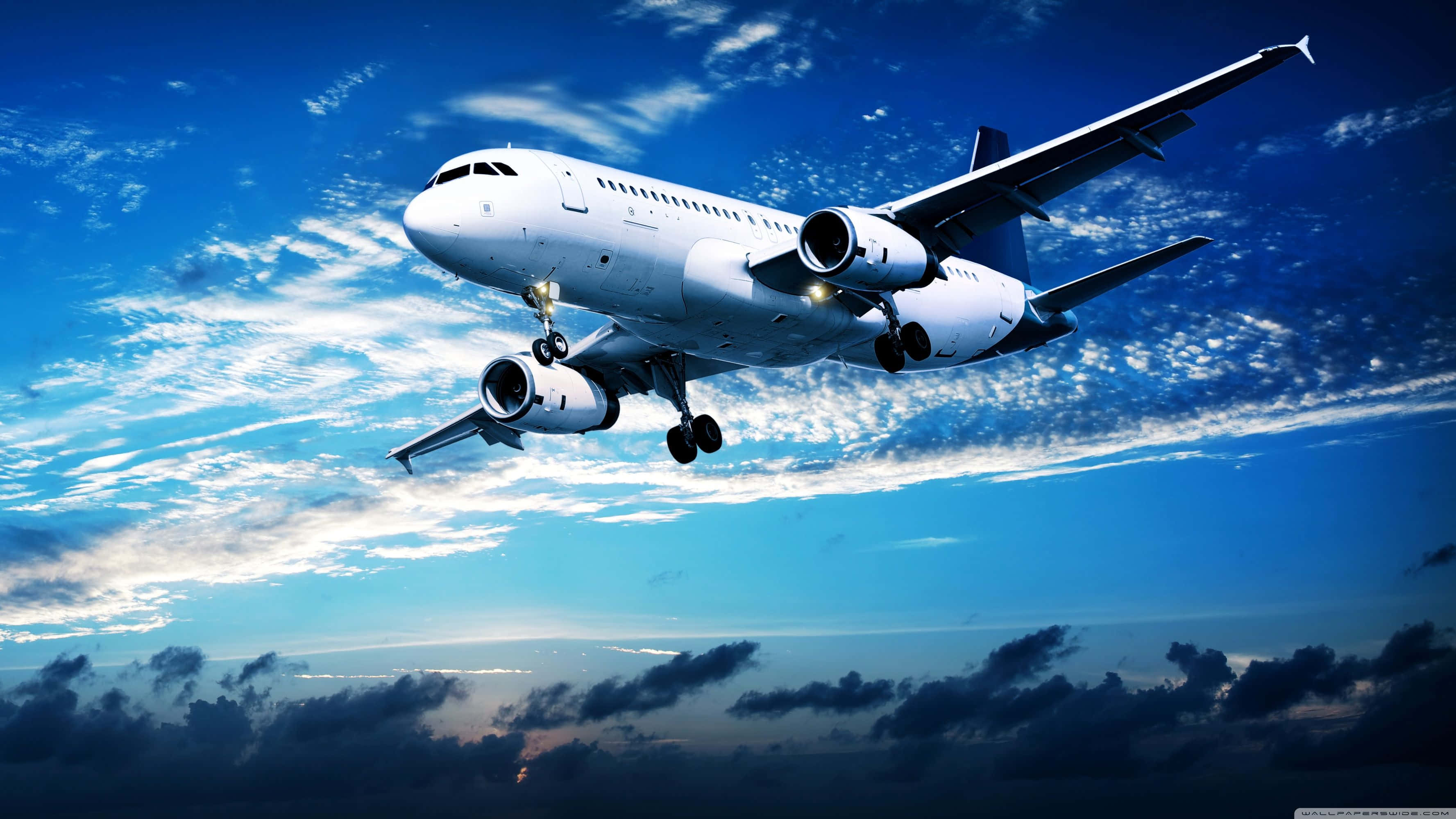 white commercial airplane, vibrant blue sky, wispy clouds, 2K Desktop Wallpaper