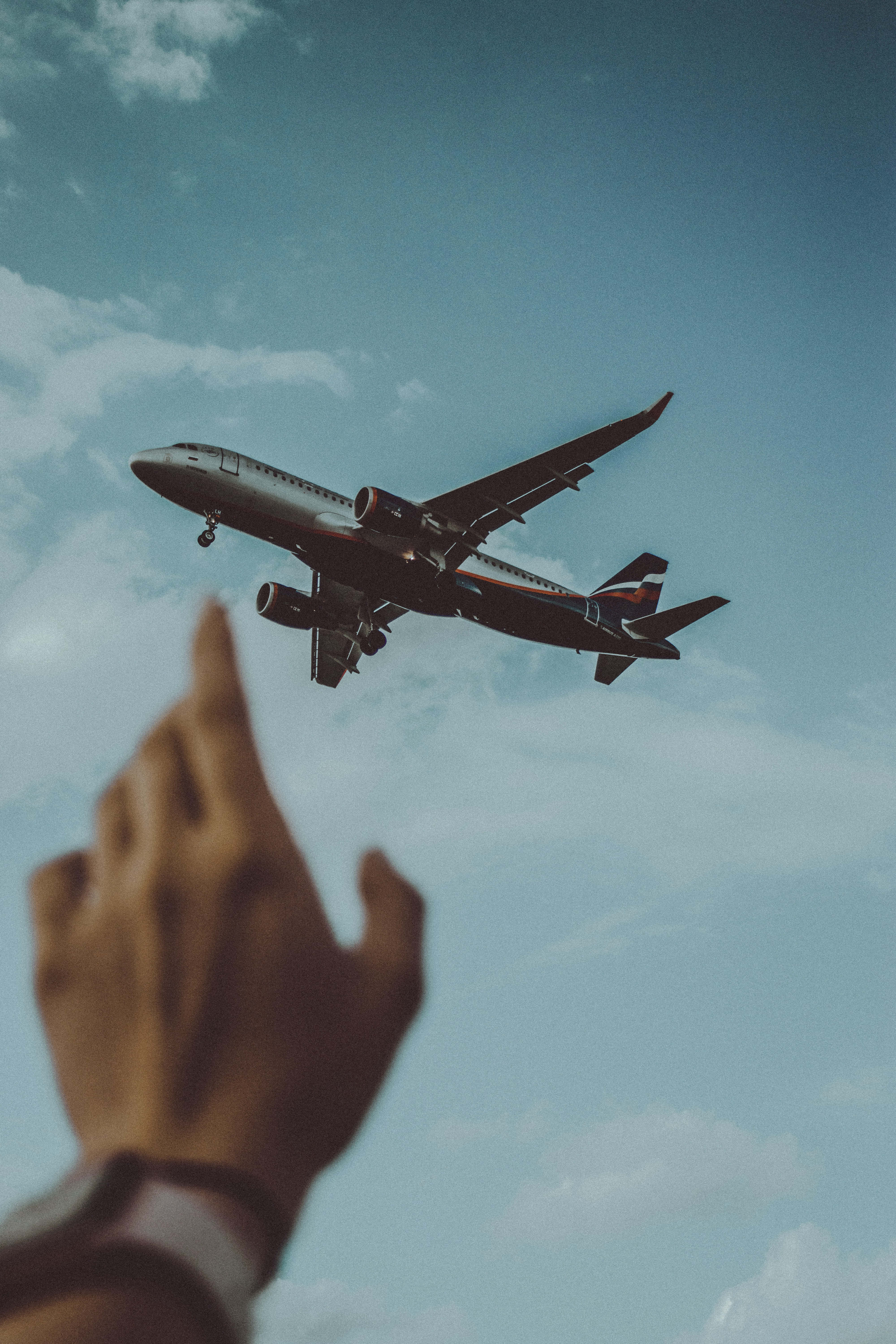 hand, commercial airplane, partly cloudy blue sky, 5K Phone Wallpaper