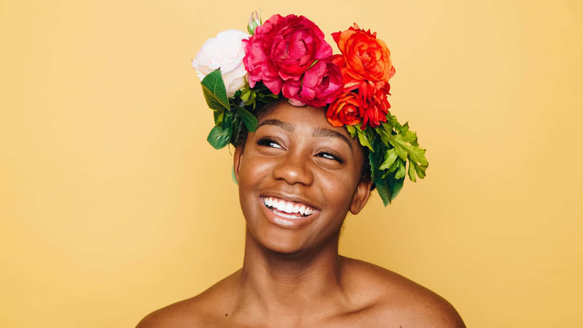 joyful woman, vibrant floral crown, warm yellow backdrop, Full HD Desktop Wallpaper