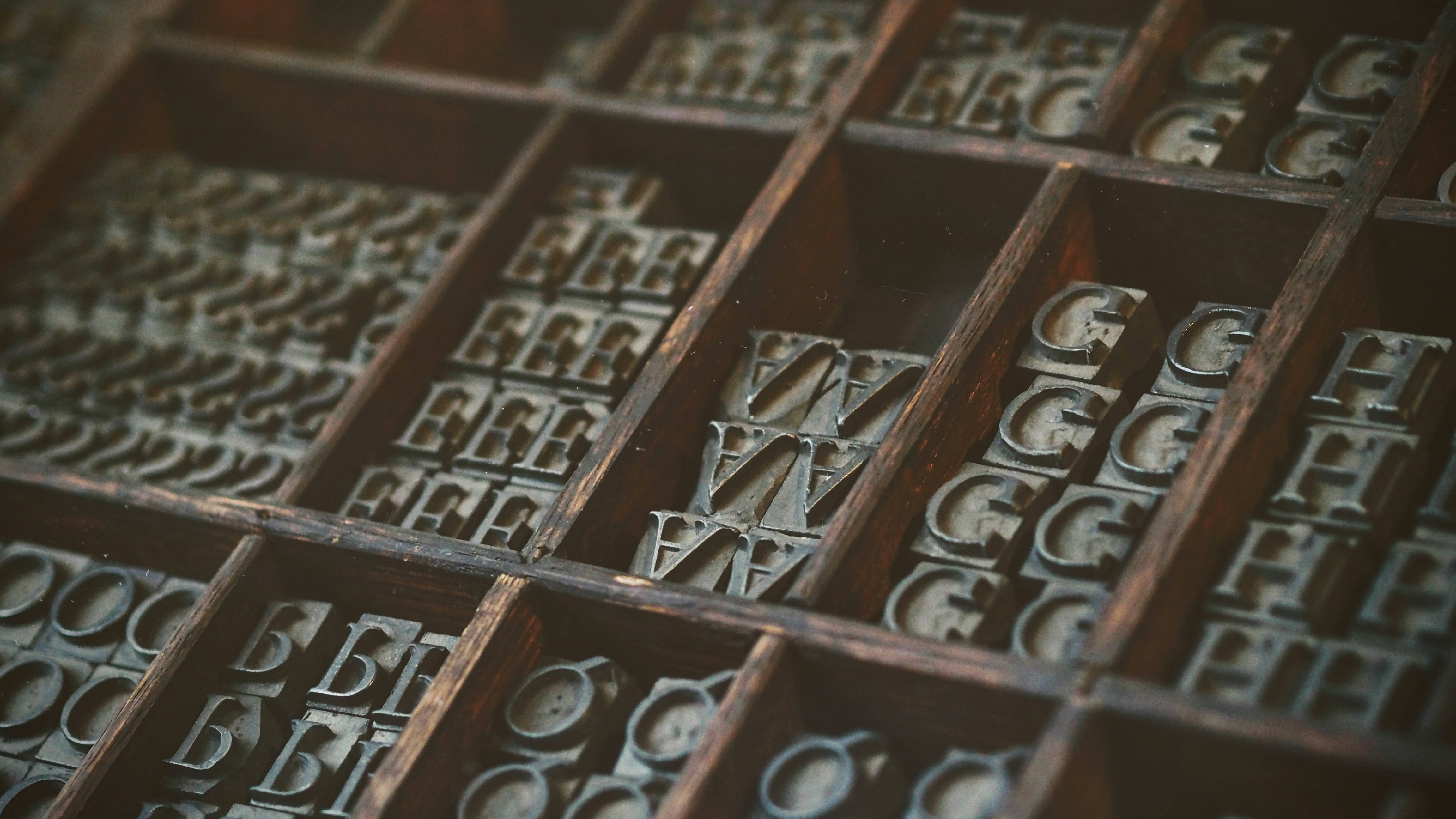 vintage metal letterpress typefaces, weathered wooden typecase, warm lighting, 4K Desktop Wallpaper