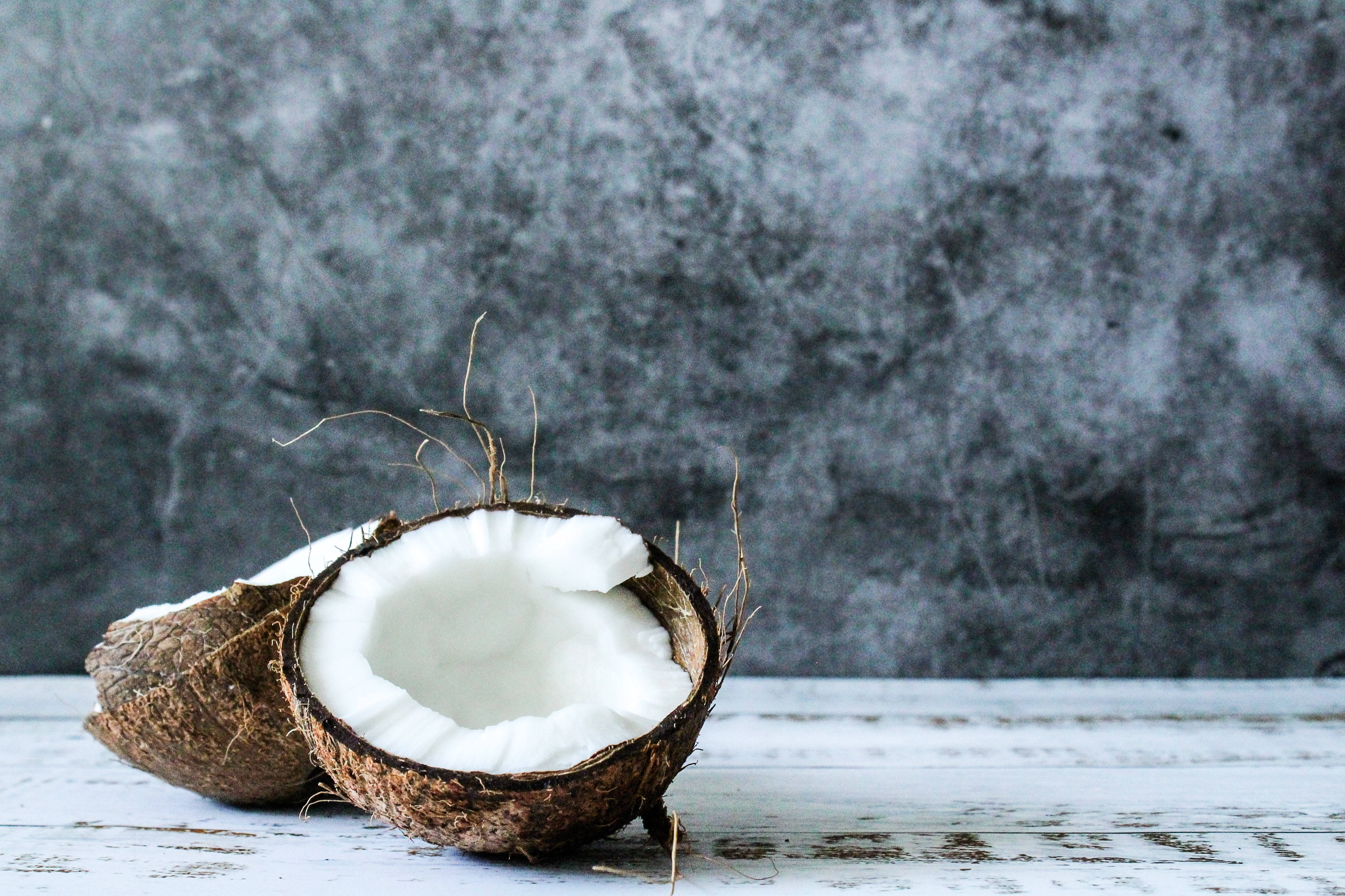 meaty coconut fruit, white flesh, weathered white wooden surface, 5K Desktop Wallpaper