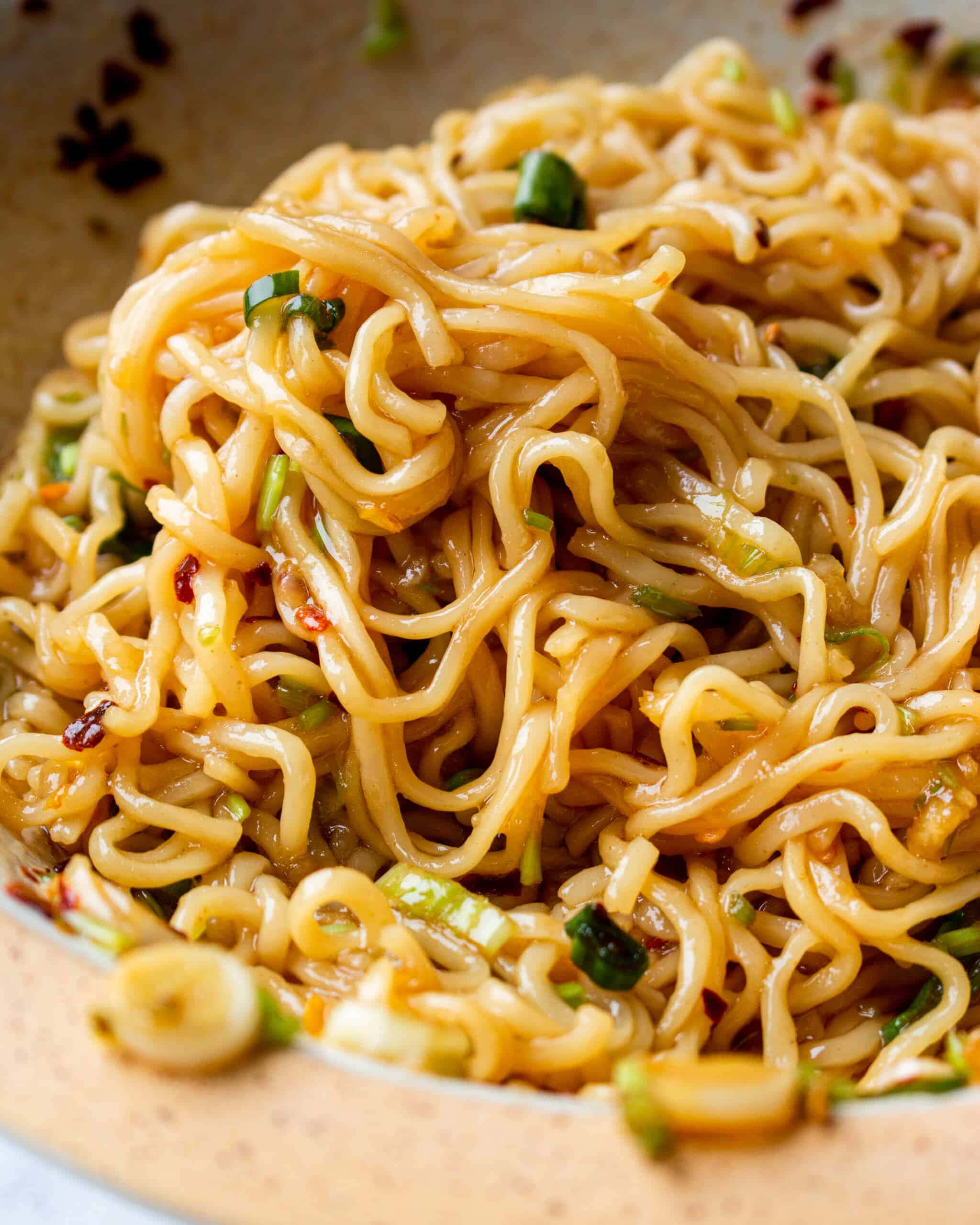 spicy chili oil ramen noodles, glossy stir-fried noodles, chopped green onions, 2K Phone Wallpaper