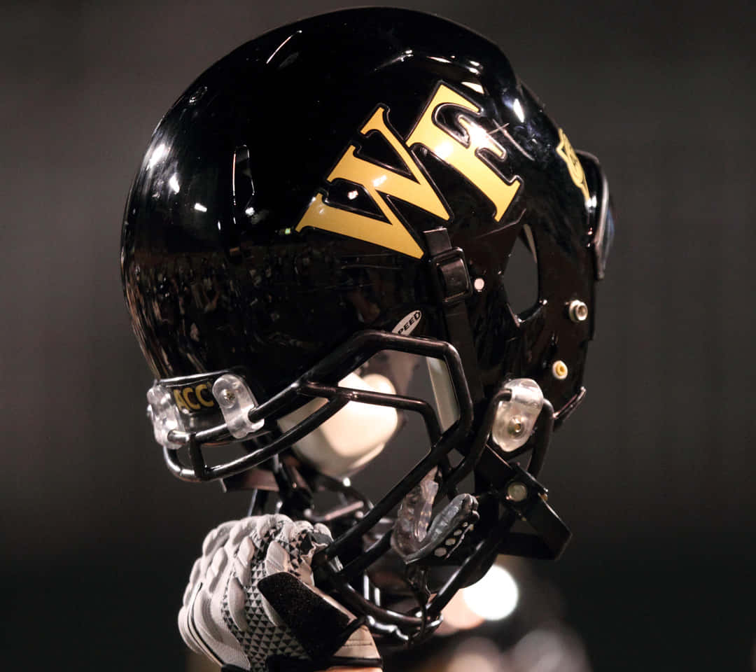 glossy black football helmet, gold 'WF' lettering, gloved hand, SD Desktop Wallpaper
