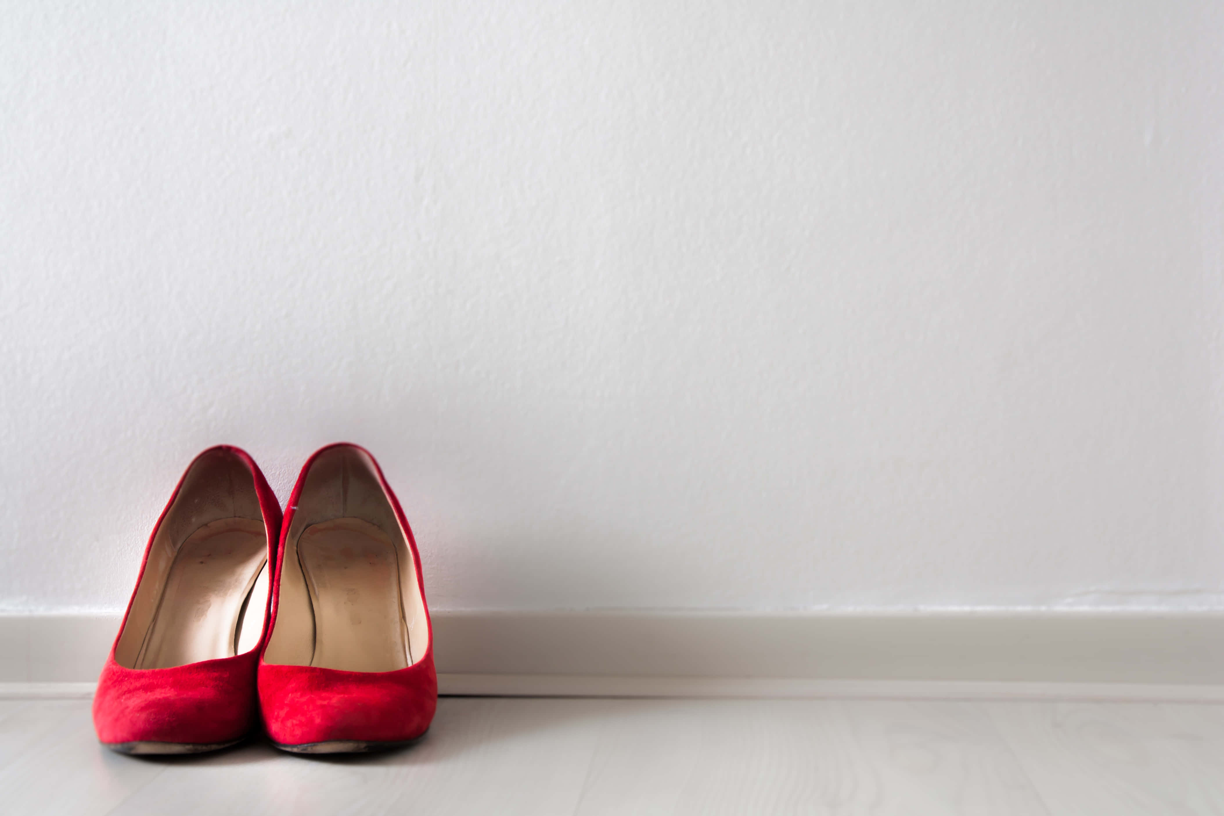 vibrant red velvet heels, light wooden floor, plain white wall, 4K Desktop Wallpaper